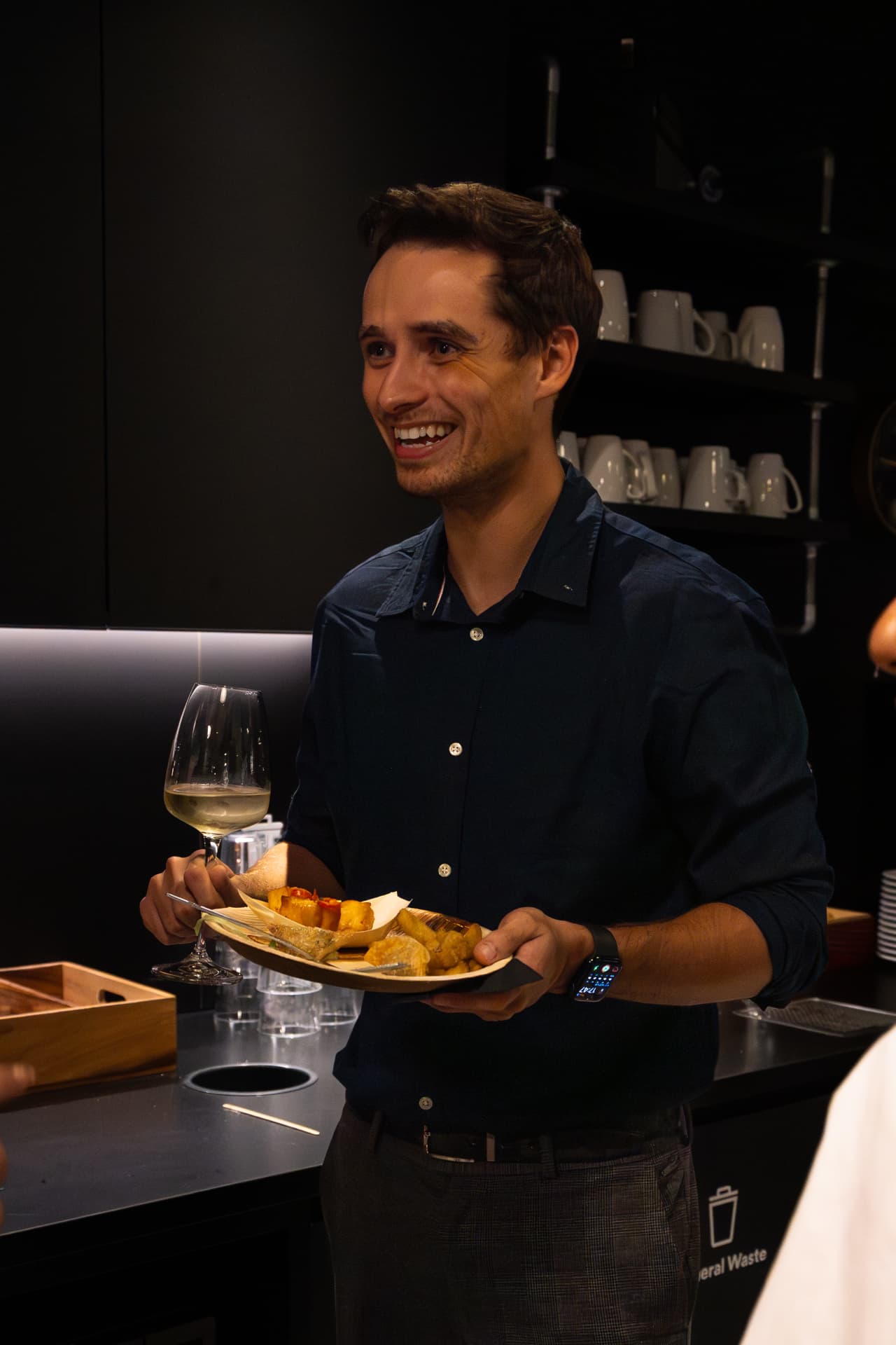 Guest with wine and canapes smiling at the reception