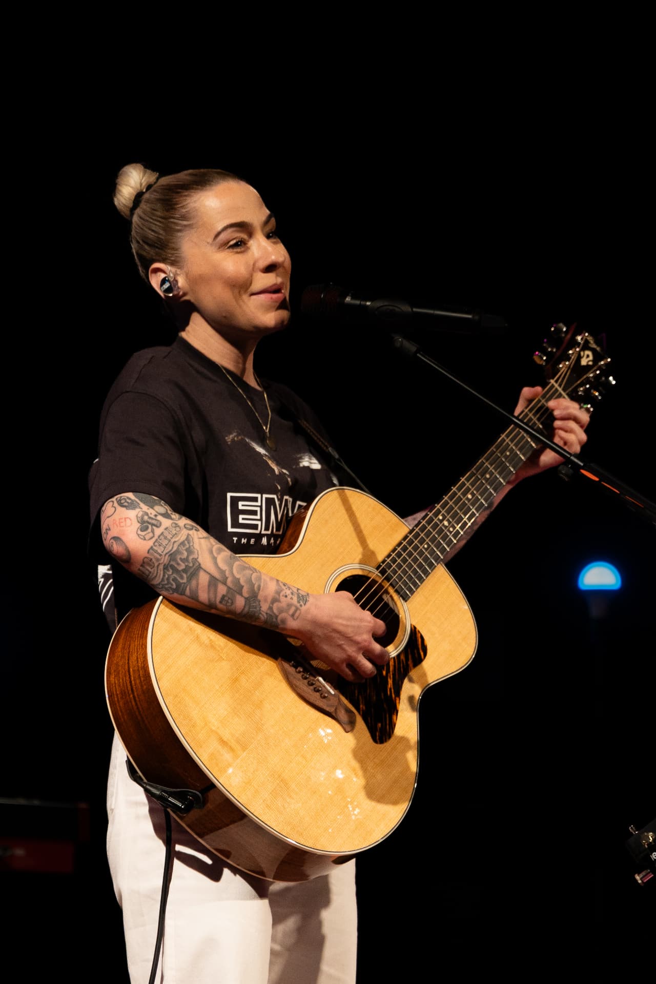 Playing guitar at the mic under warm light
