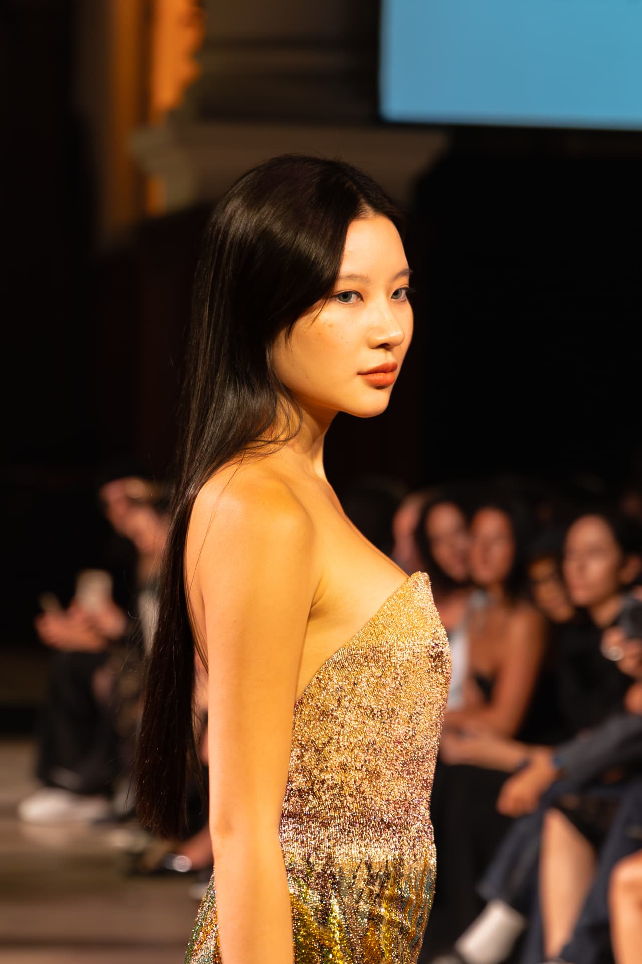 Profile of a model in a gold sequin gown