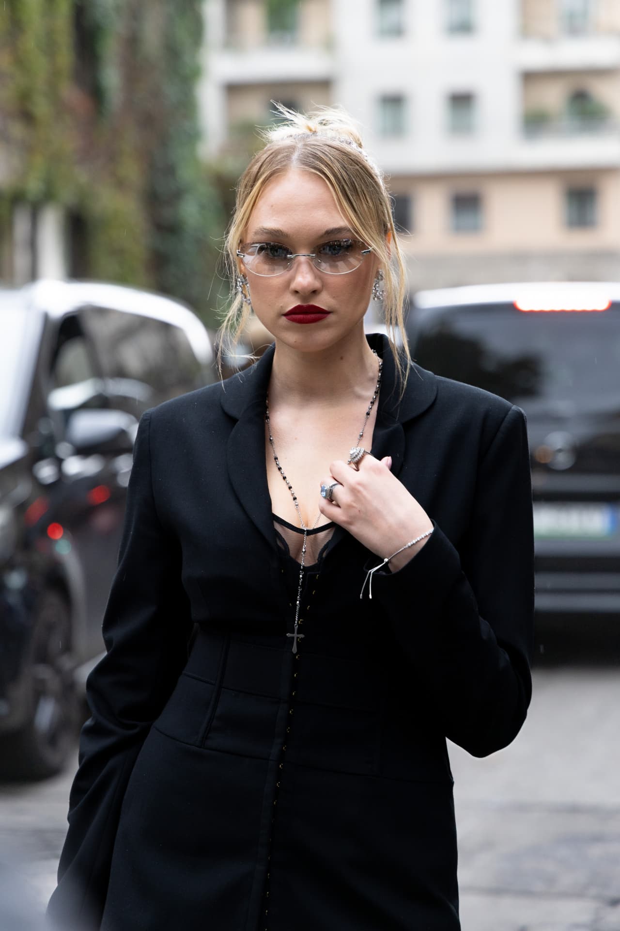 Guest in a black tailored coat with rimless sunglasses