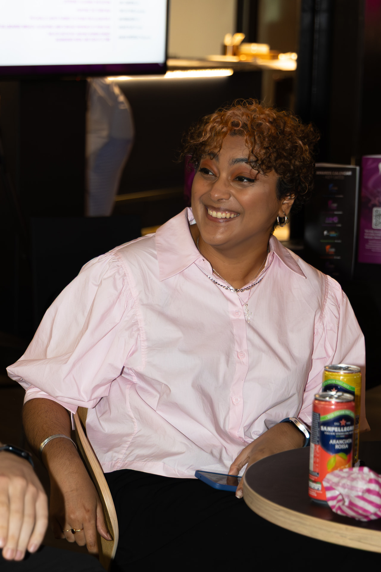 Guest in a pink shirt laughing at the table