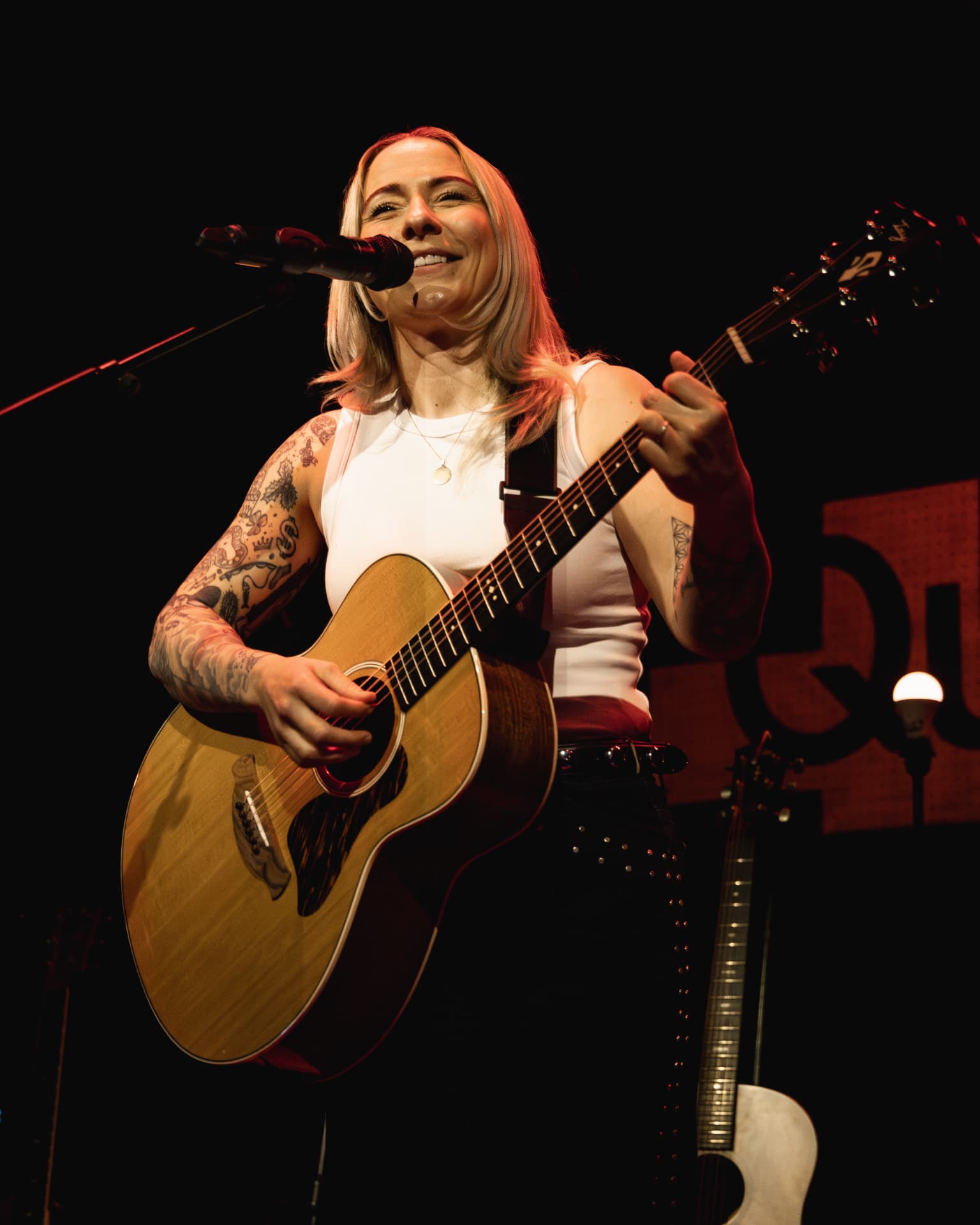 Singing into the mic in warm red light