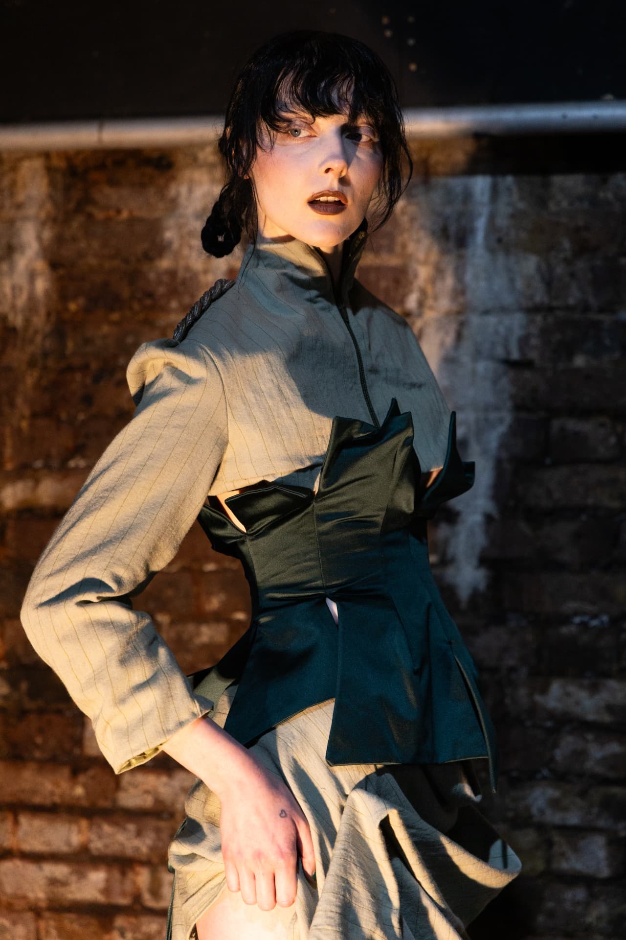 Model in structured pinstripe and green satin look backstage