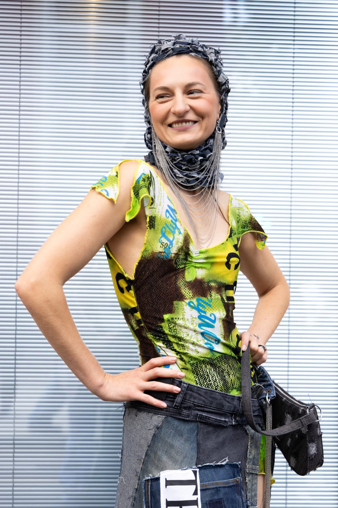 Guest in a printed mesh top with denim patchwork skirt and hood