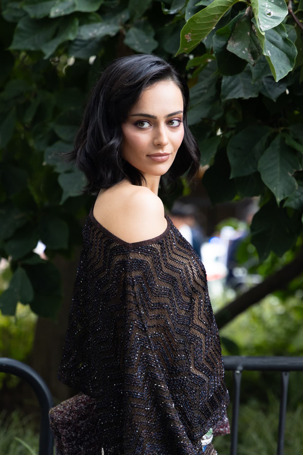 Guest in a sequinned off-shoulder knit under trees