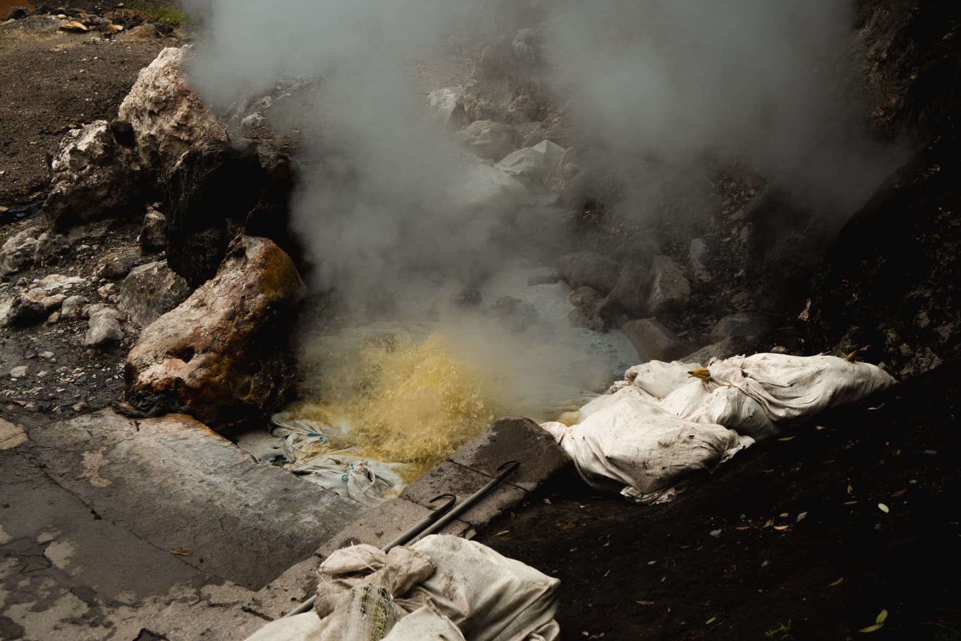 Steaming geothermal pool with sulphur-coloured water