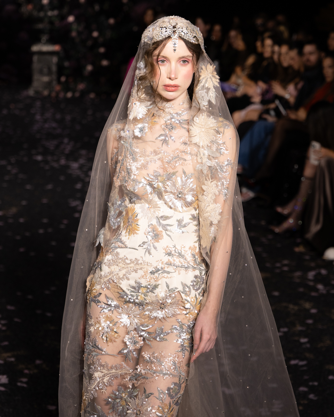 Model in a floral embroidered gown beneath a sheer veil