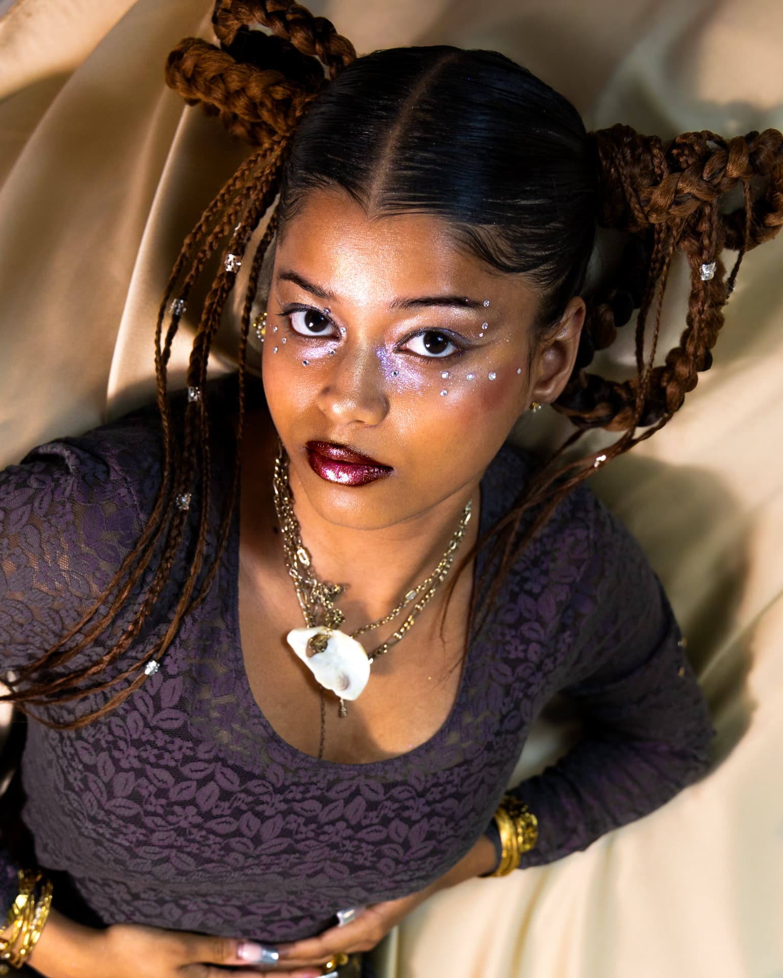 High-angle portrait with shell pendant and glitter makeup
