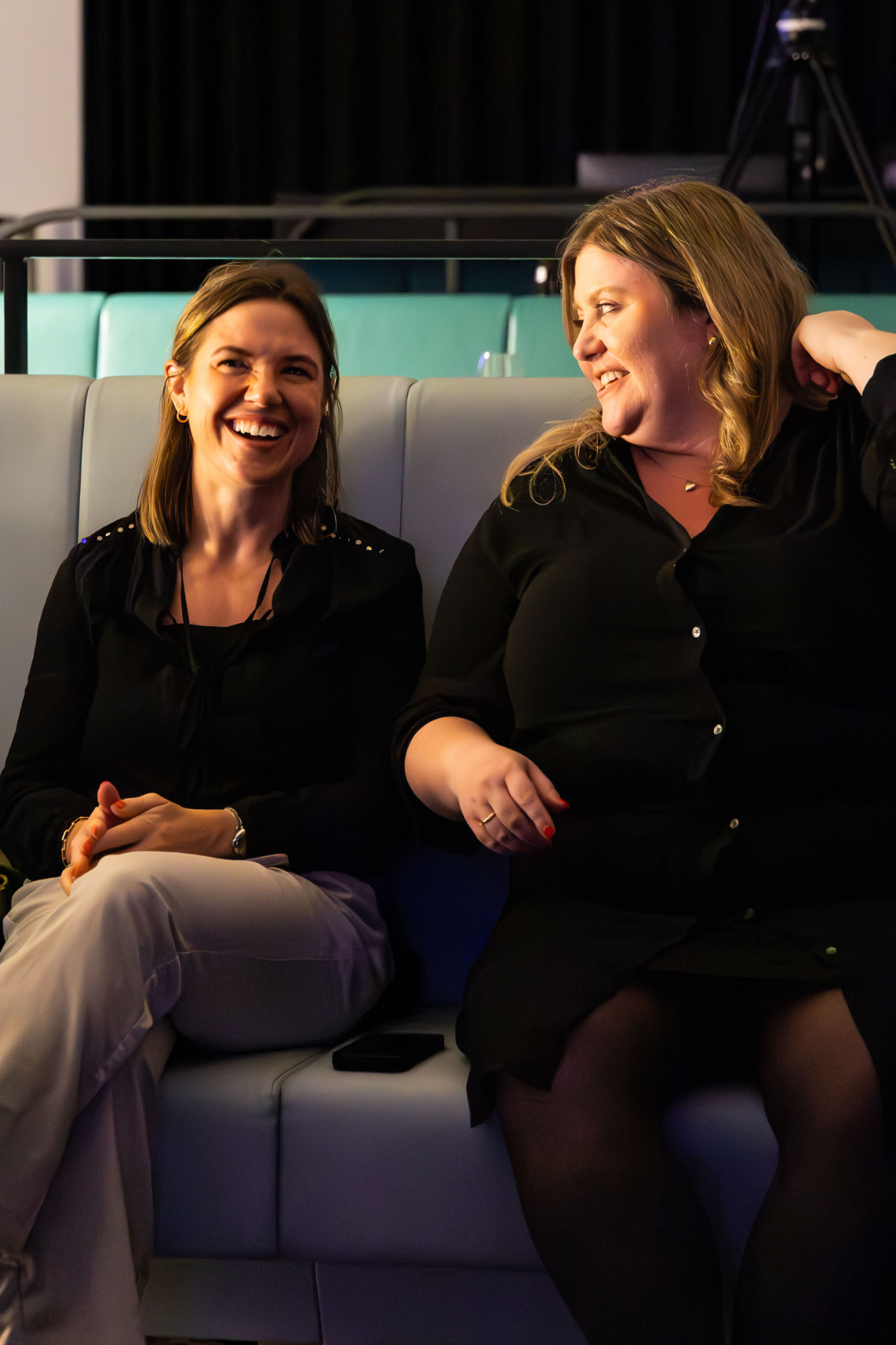 Two guests sharing a laugh on a sofa