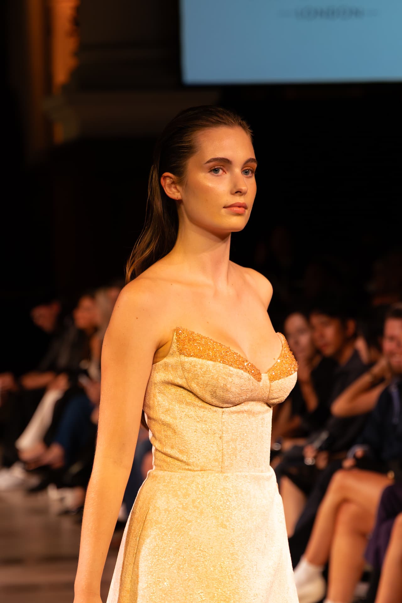 Model in a gold crystal corset gown