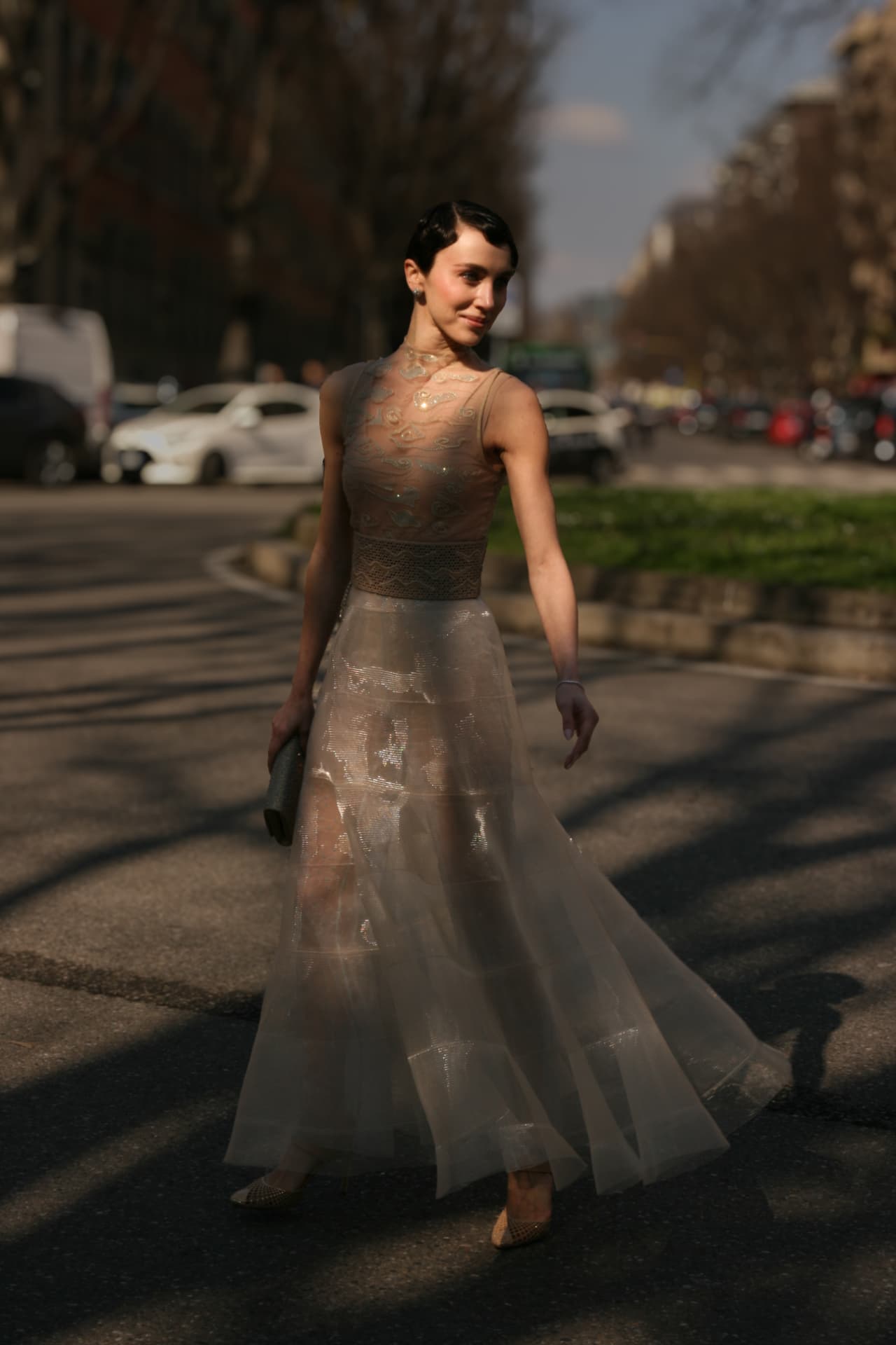 Guest in a sheer embroidered tulle gown crossing the street