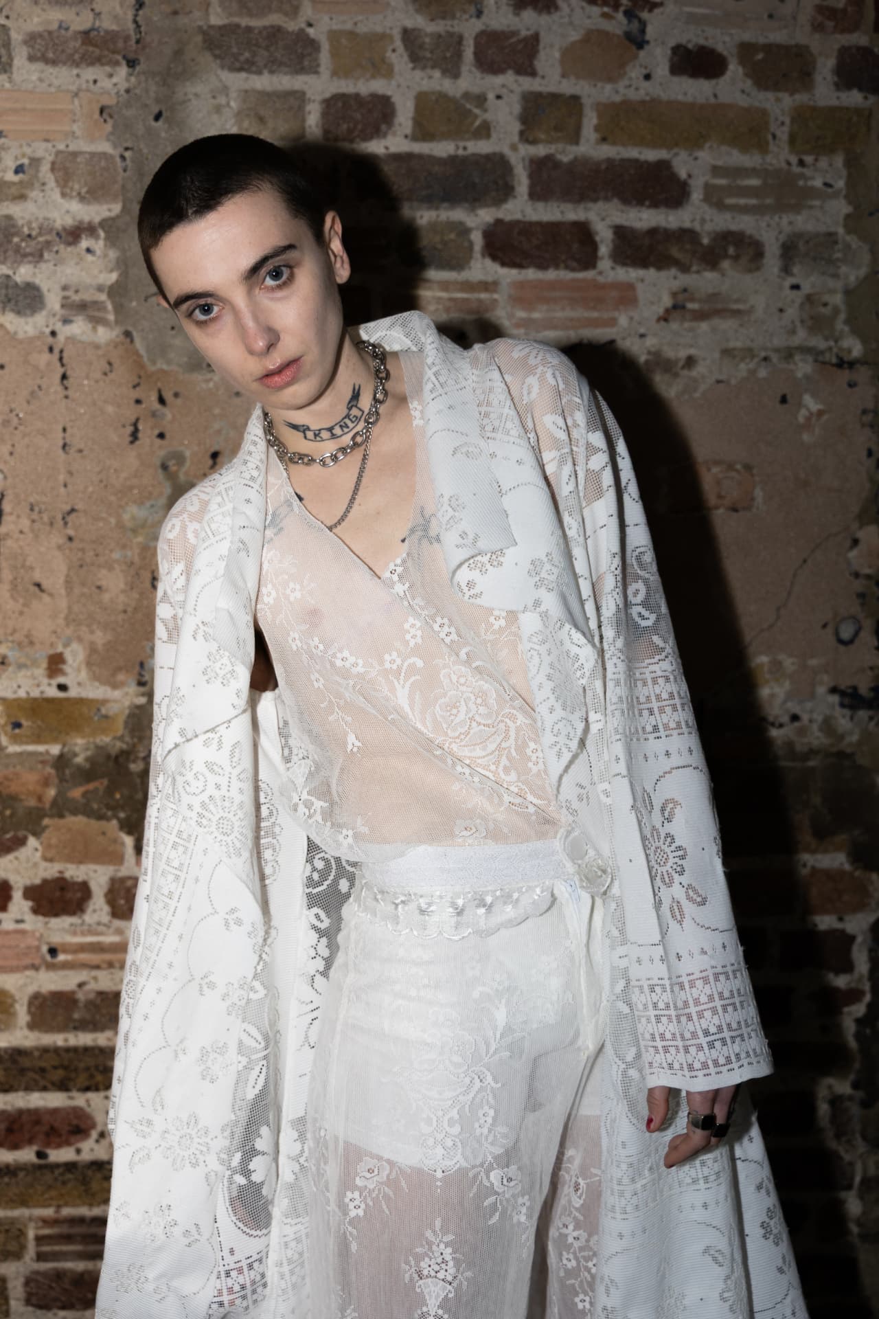Model in white lace shirting and skirt backstage