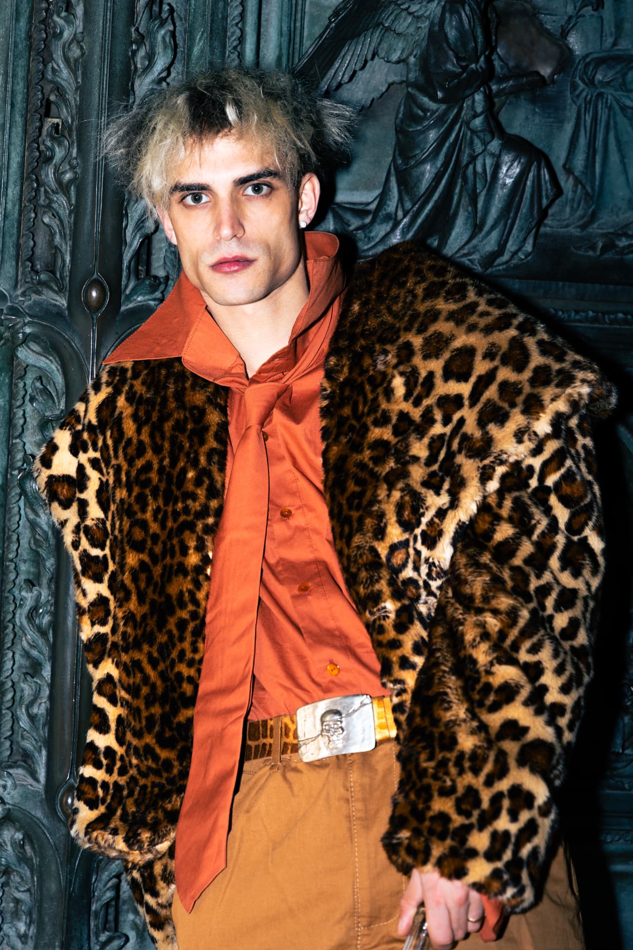 Model in a leopard print coat with an orange shirt