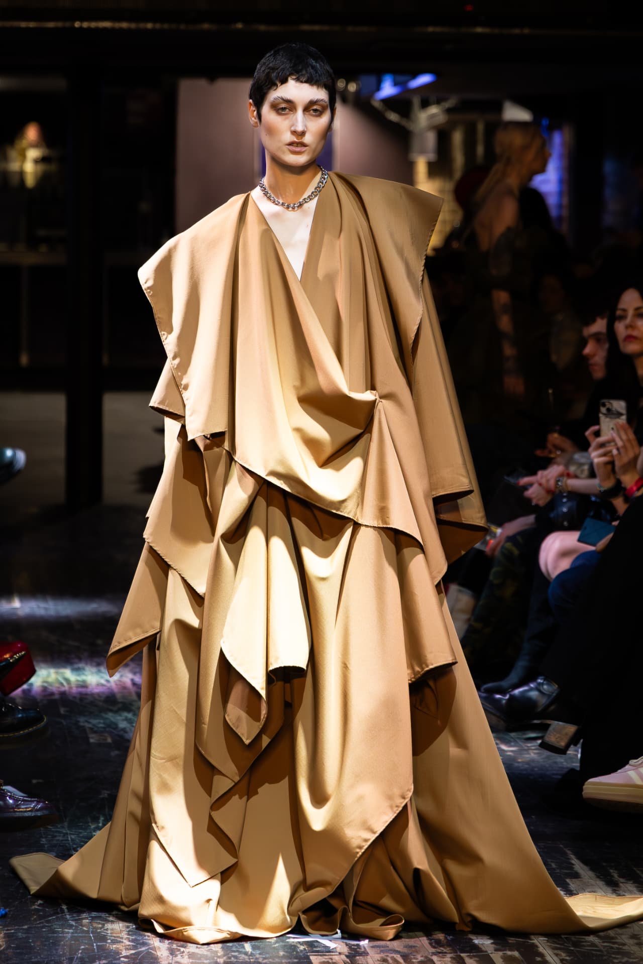 Model in a draped caramel satin cape gown