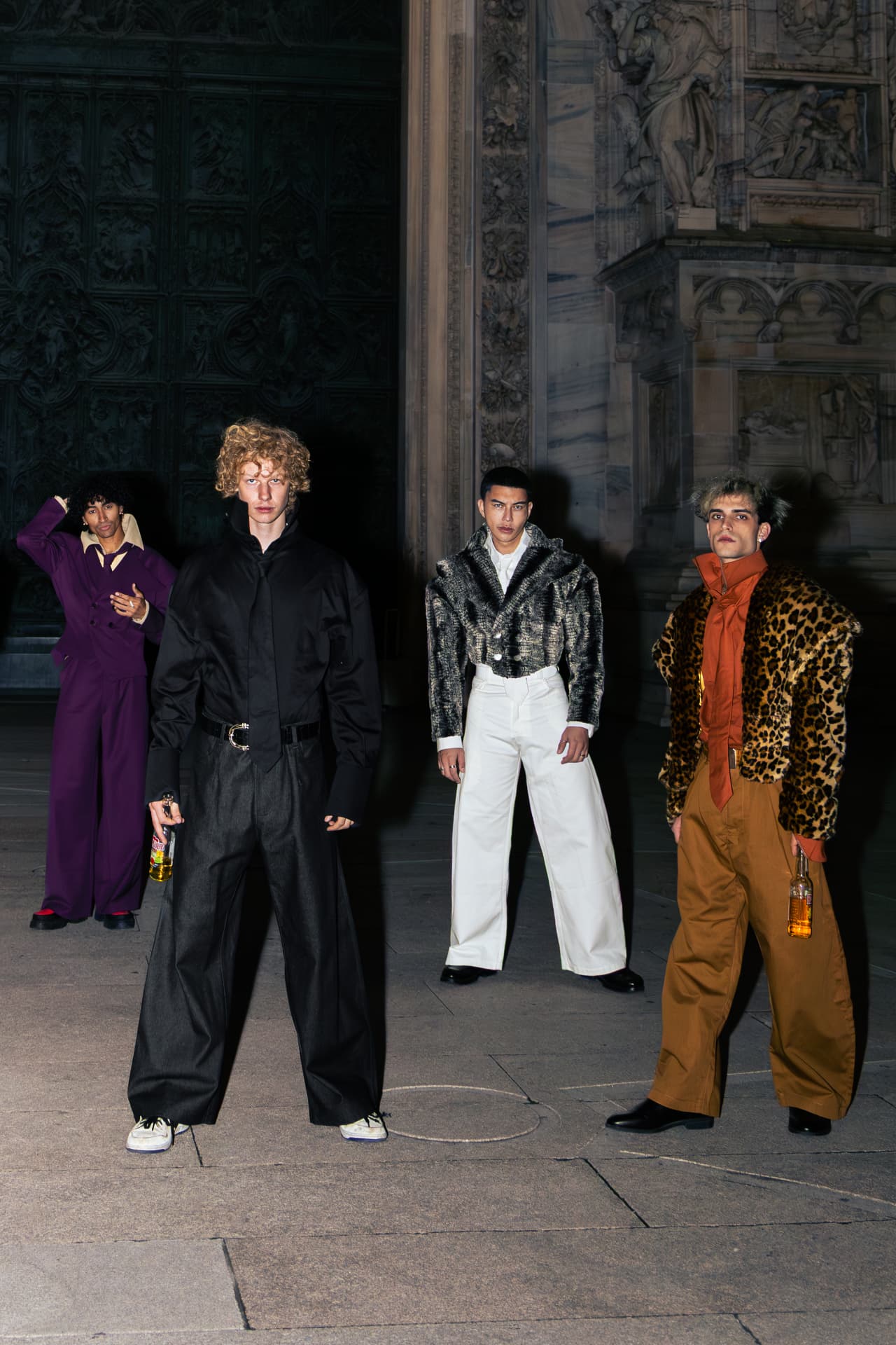 Four models spread across the cathedral steps at night