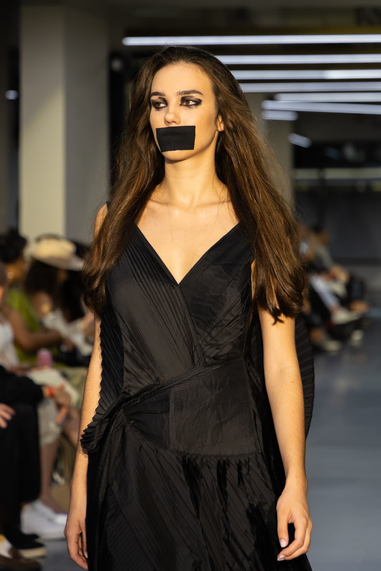 Model in a black pleated slip gown
