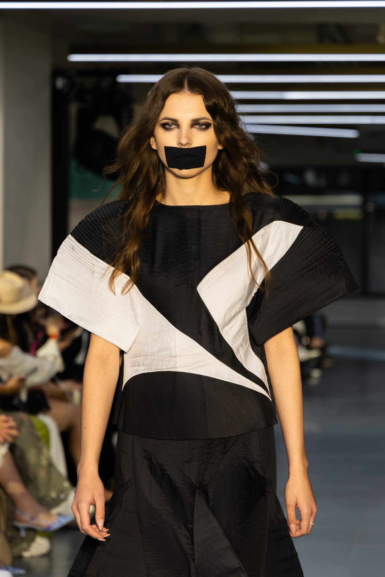 Model in a black and white graphic pleated top
