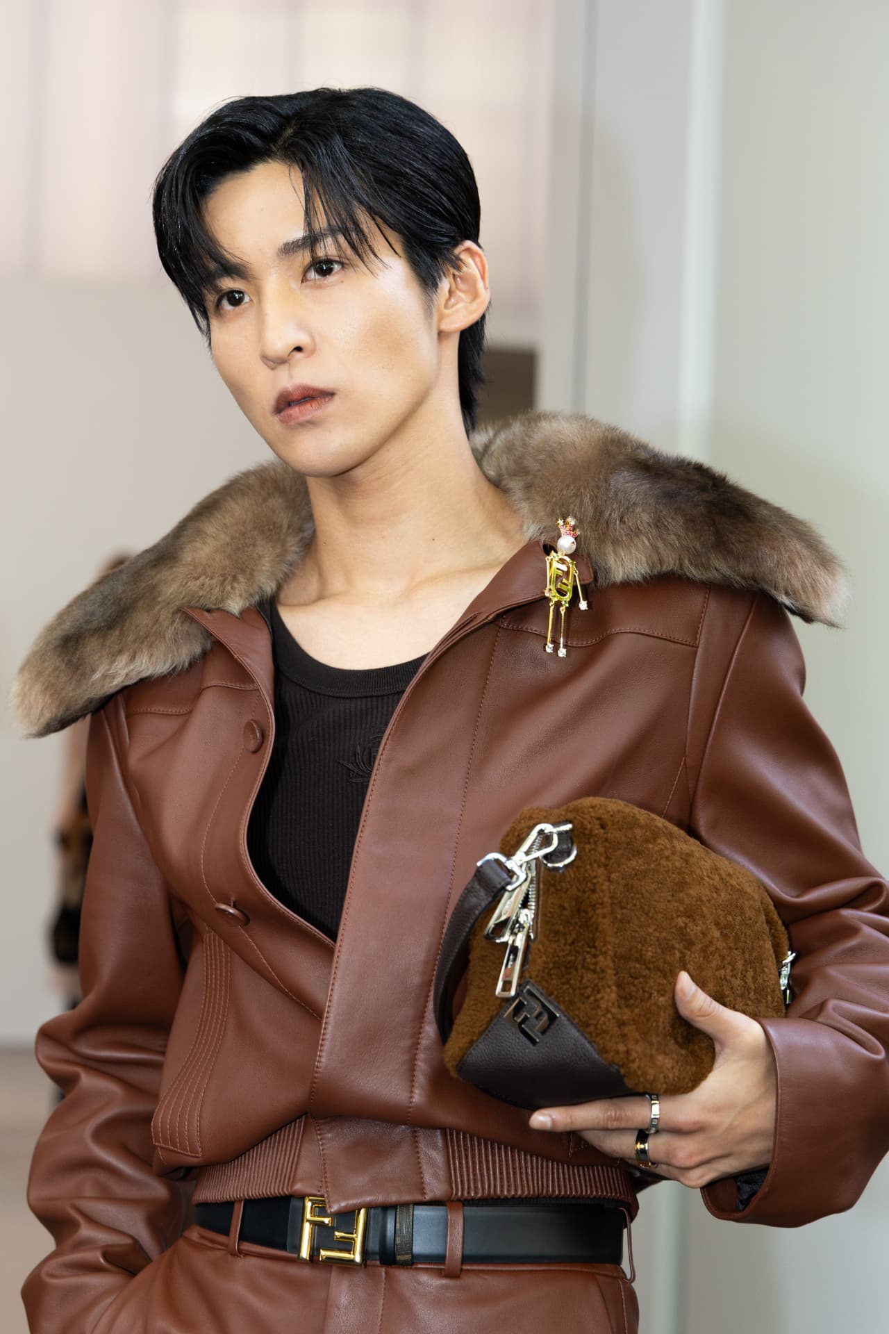 Guest in a brown leather fur-collared jacket with shearling bag