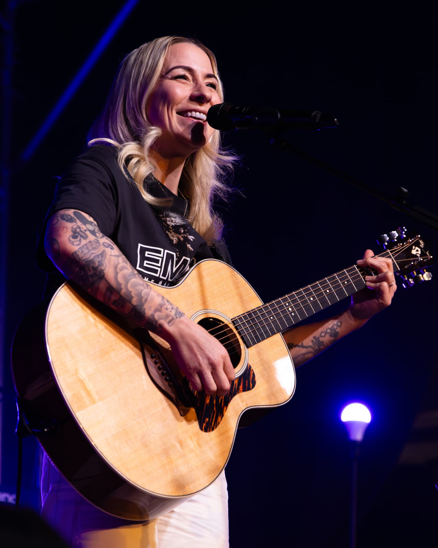 Lucy Spraggan singing in blue stage light