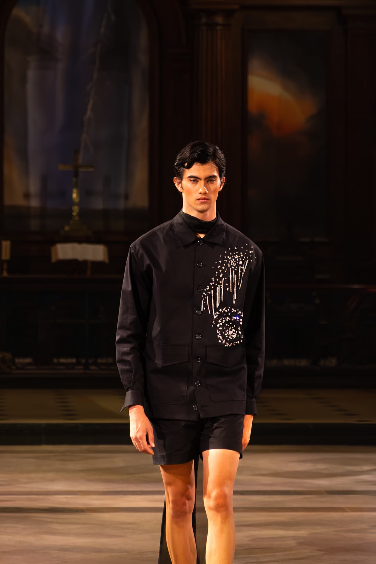 Model in a black embellished shirt and shorts