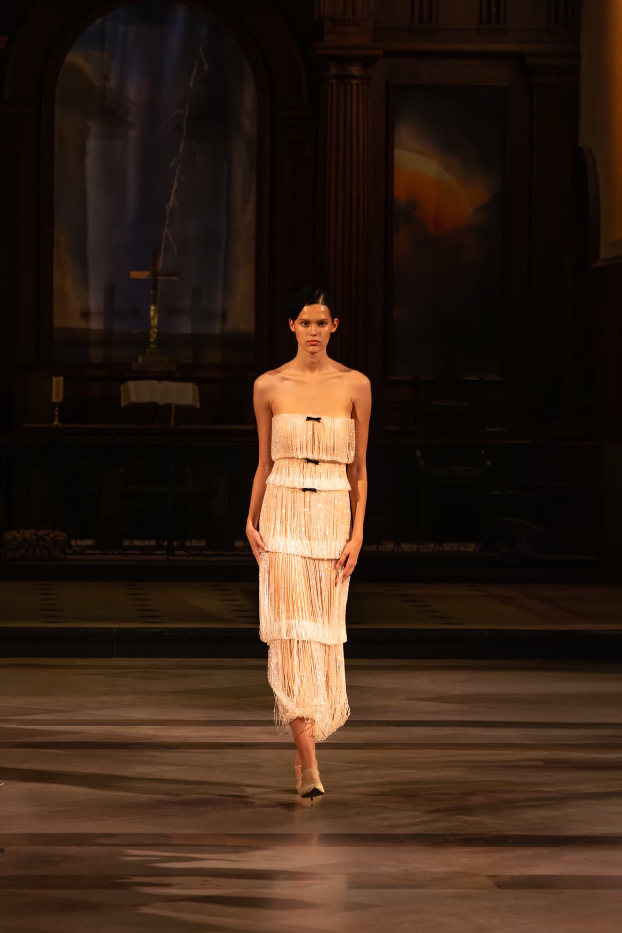 Model in a fringed strapless dress with black bows