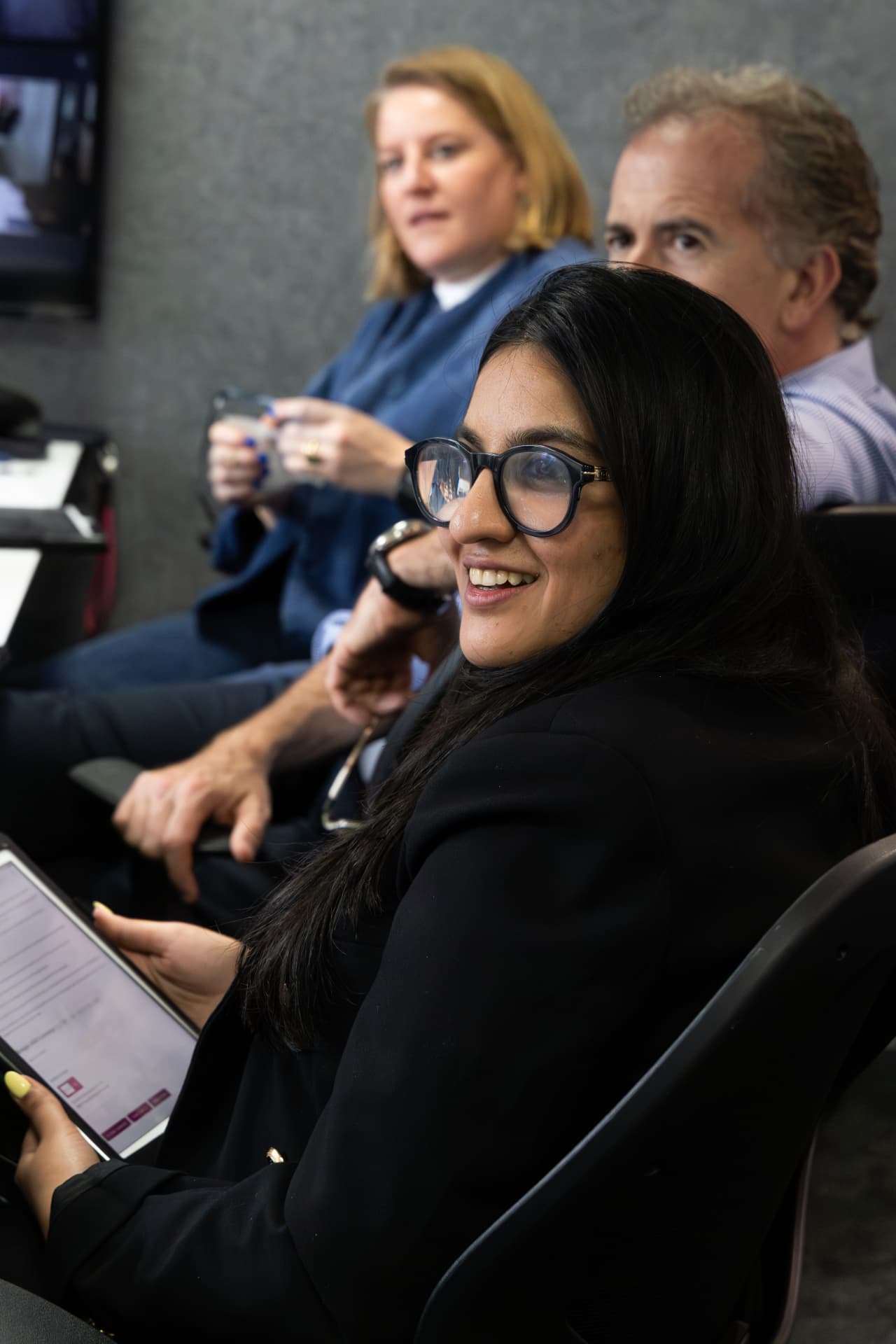 Judge smiling with a tablet in hand