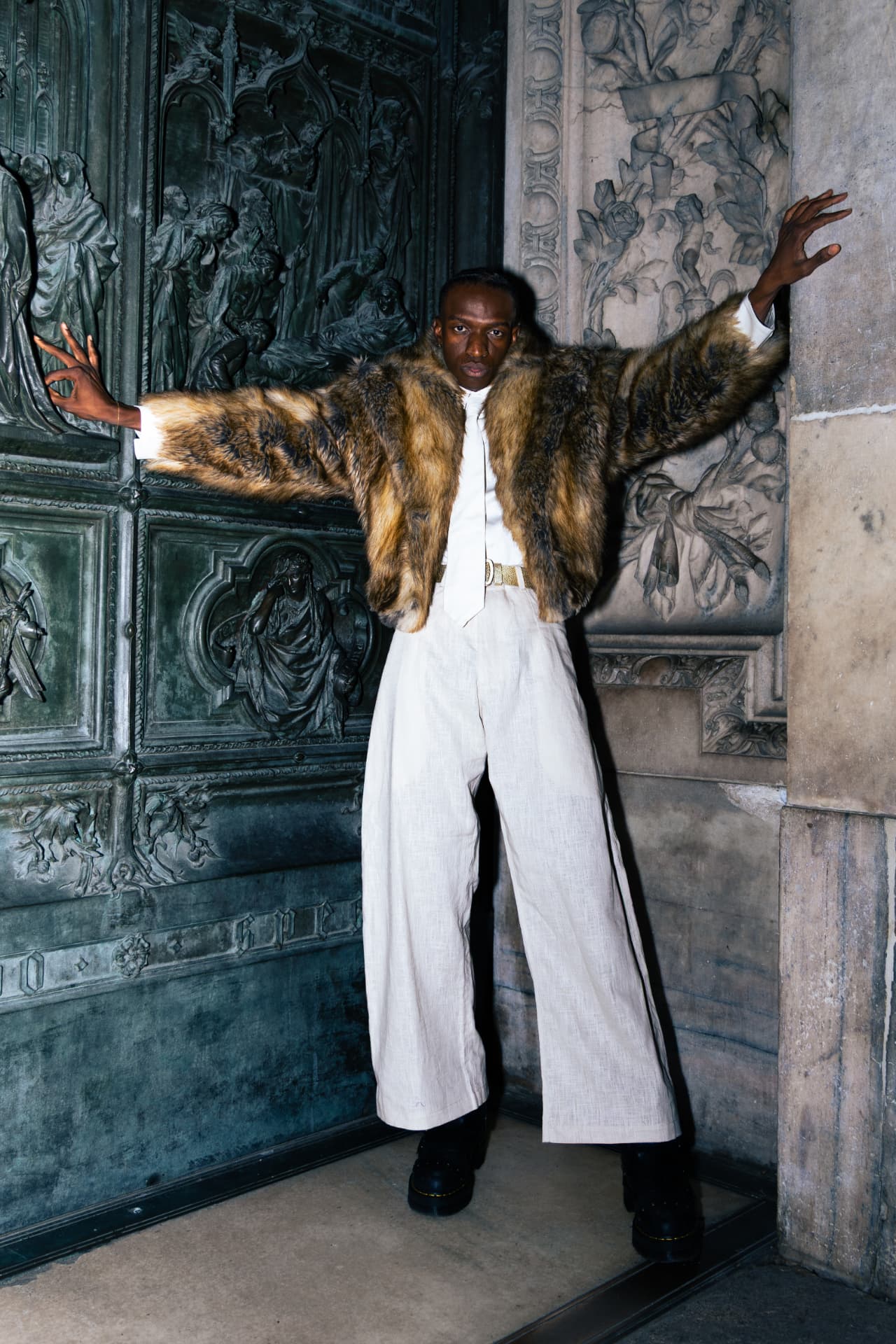 Model in a tan fur coat with arms outstretched