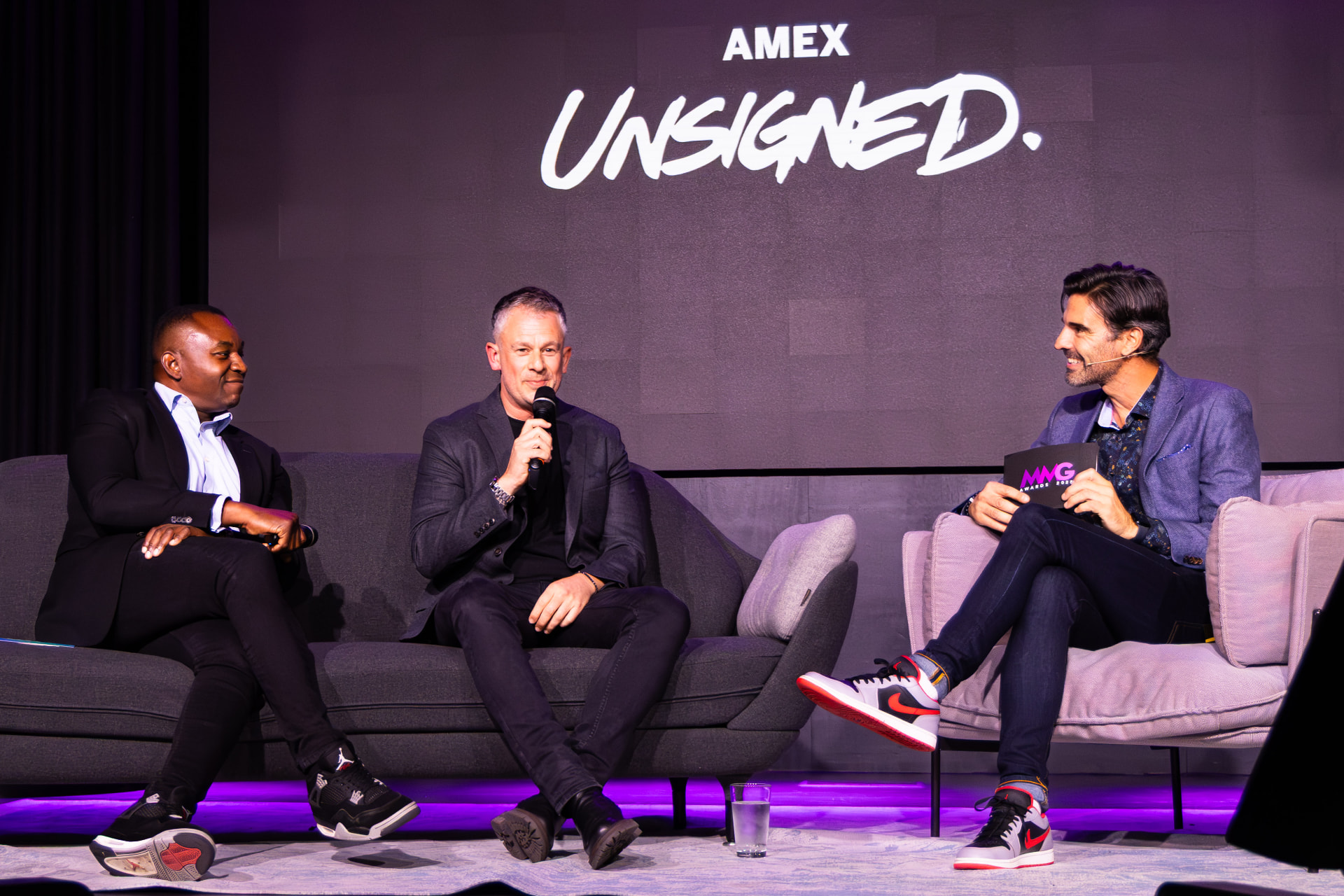 Panel discussion on stage under the Amex Unsigned screen