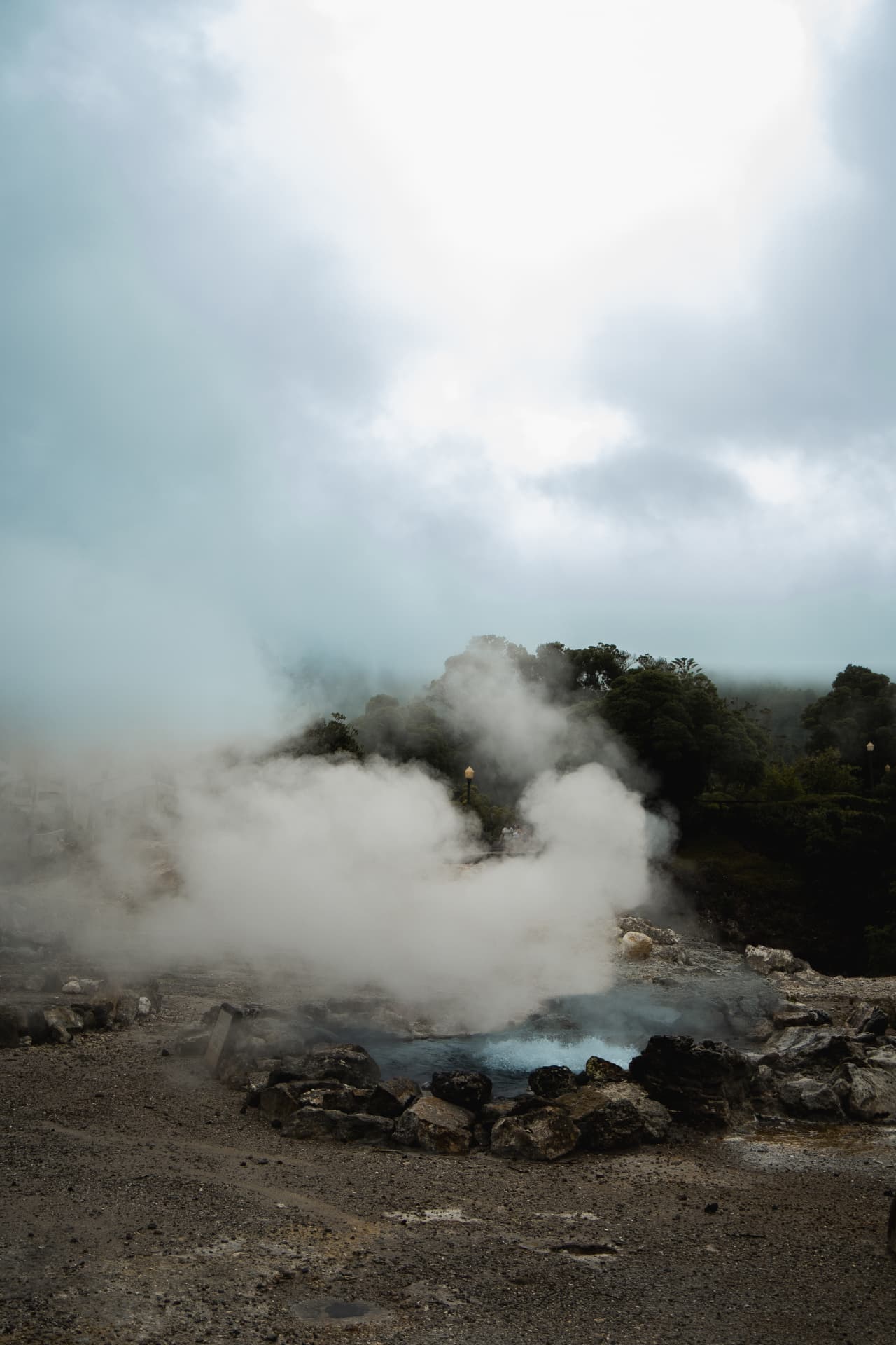 Steaming geothermal pool under a cloudy sky
