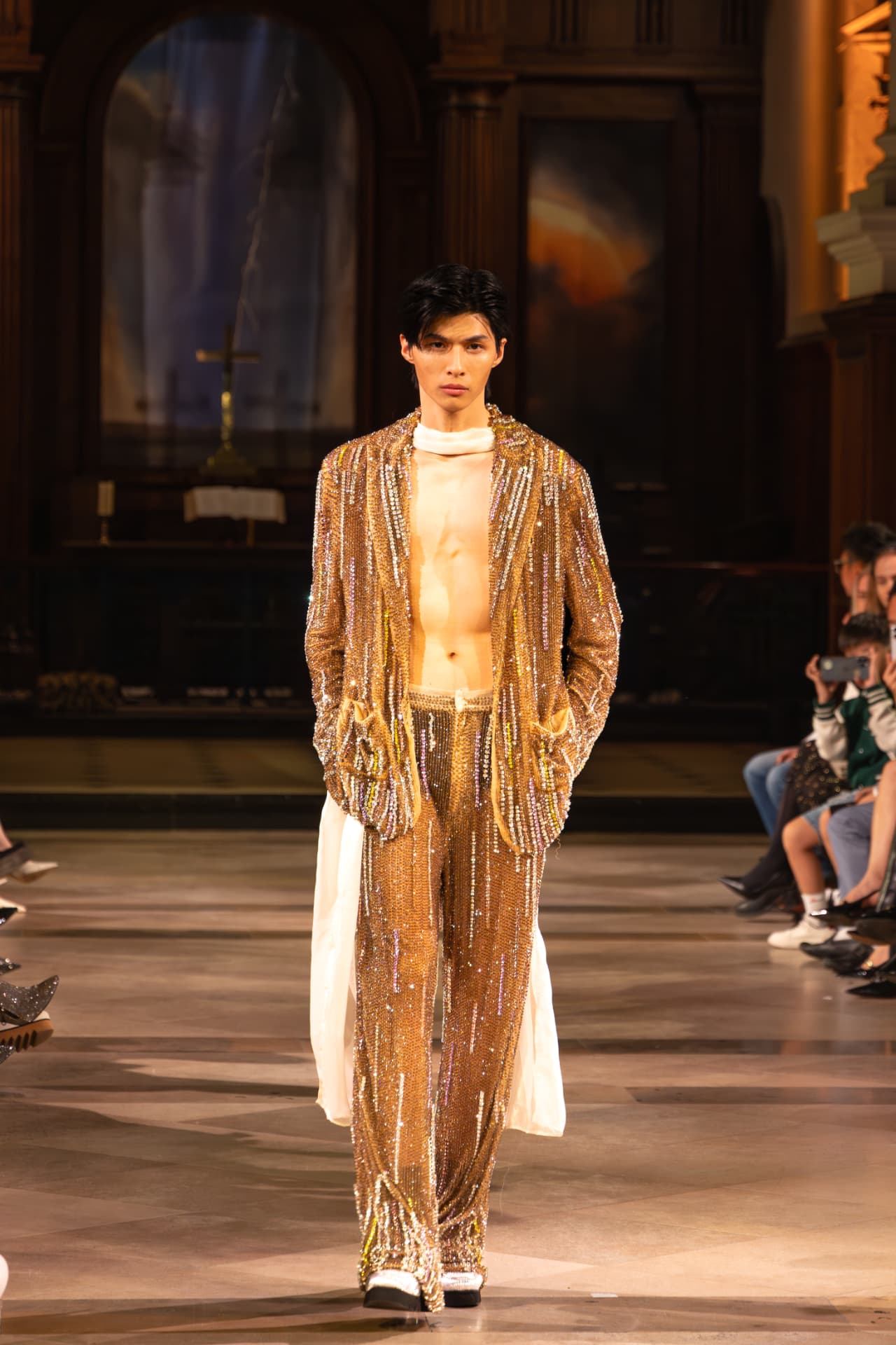 Model in a gold crystal suit on the runway