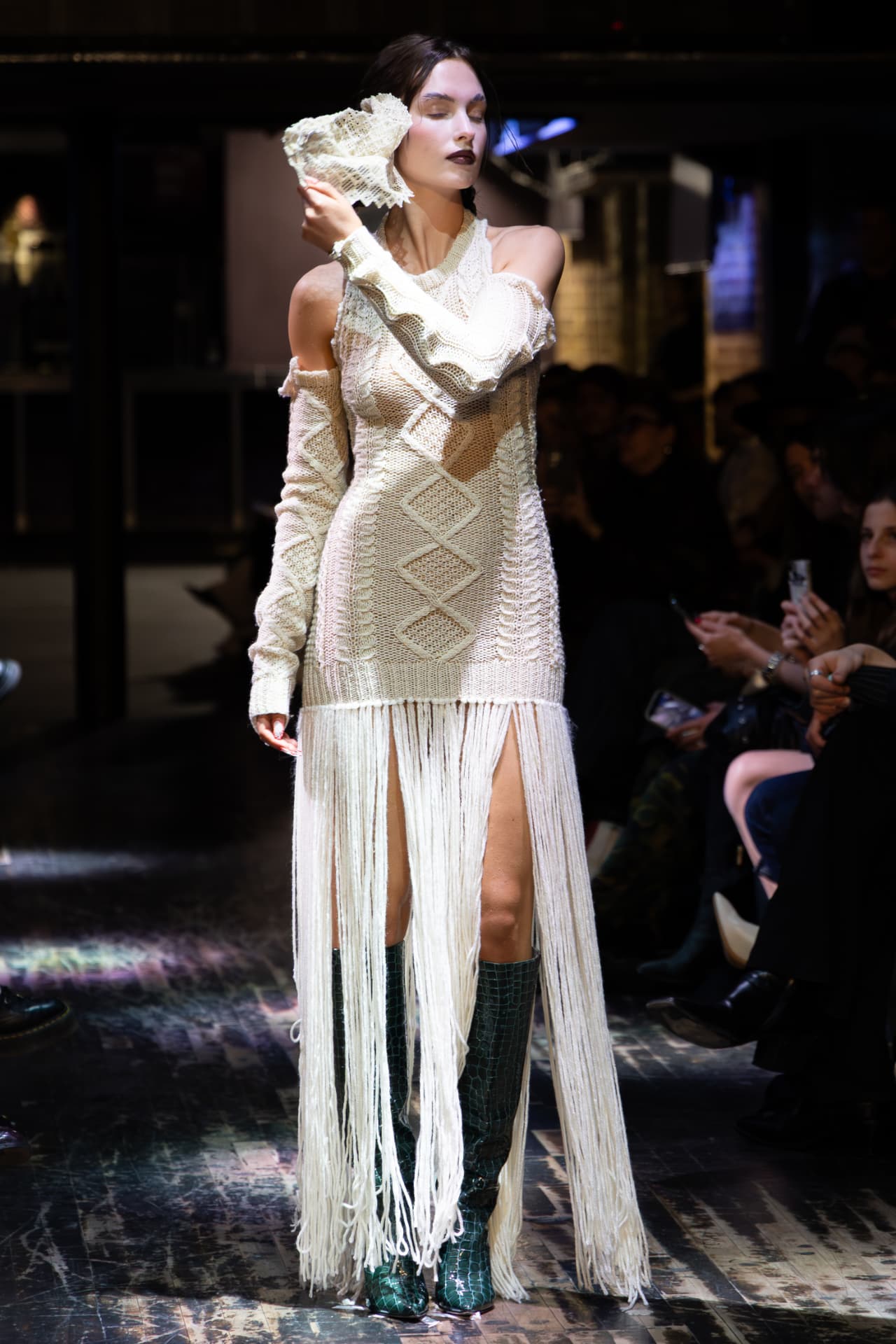Model in a cream cable knit dress with long fringing