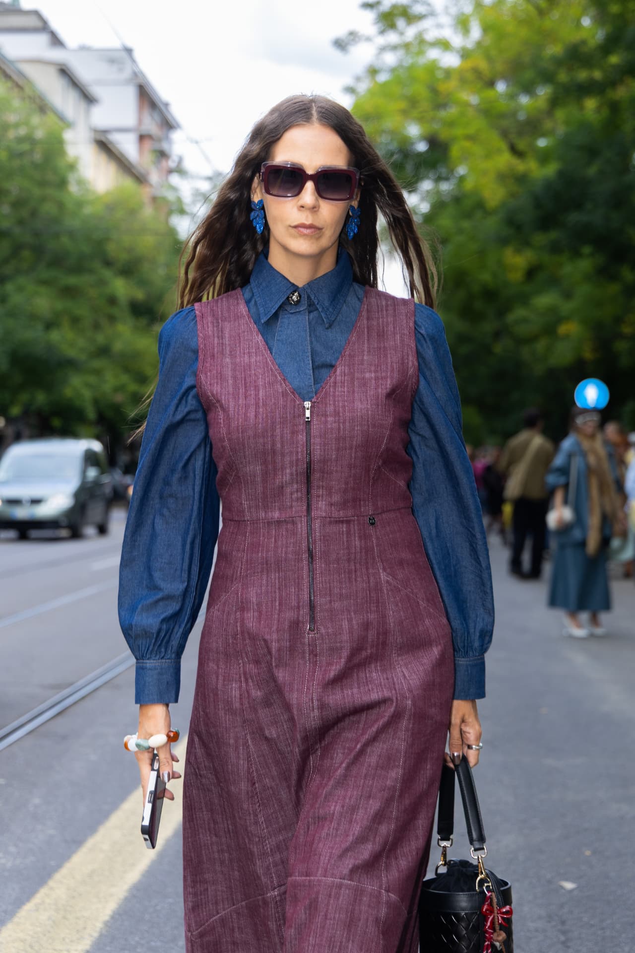 Guest in a burgundy denim pinafore over a chambray shirt