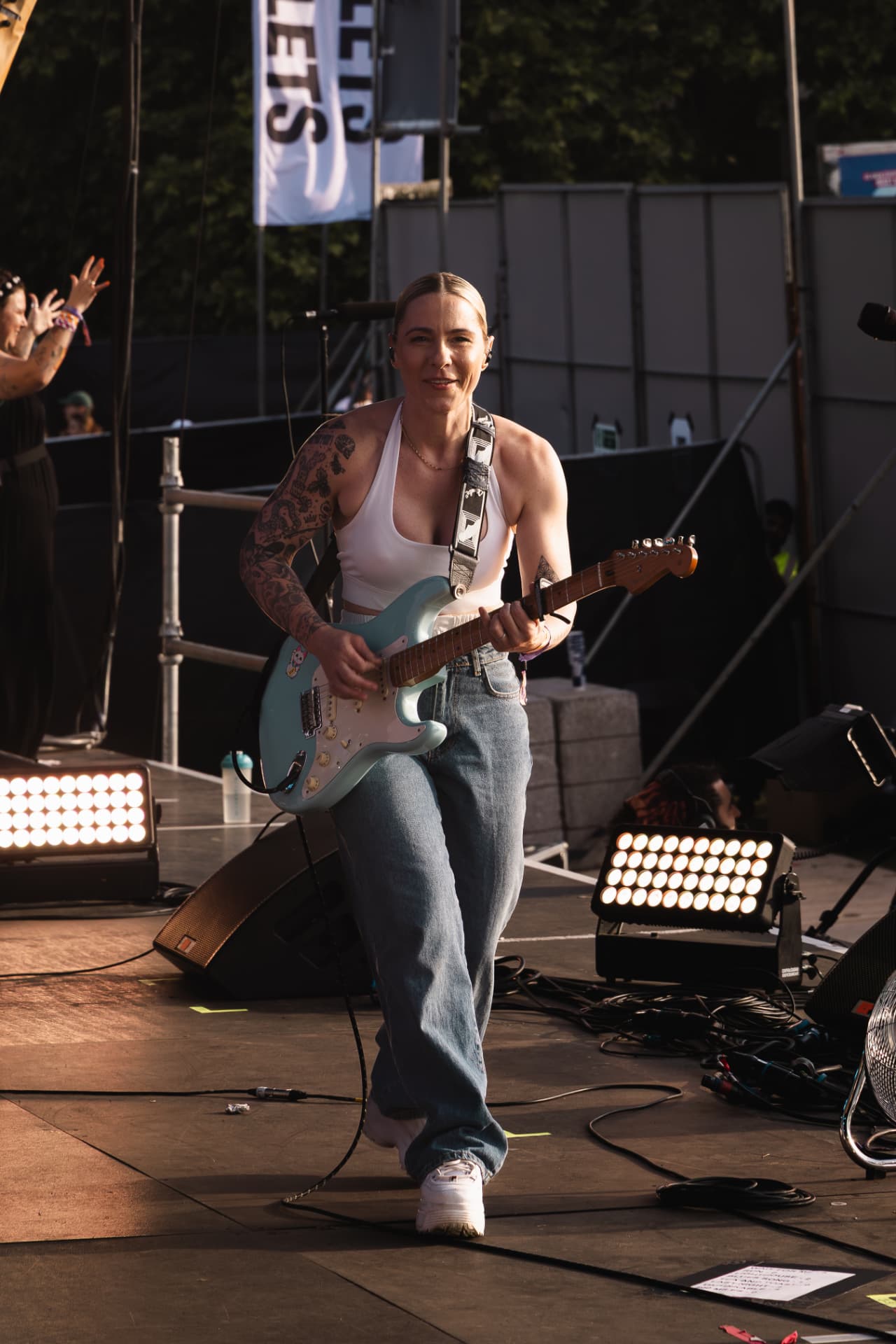 Walking the stage with guitar in evening light