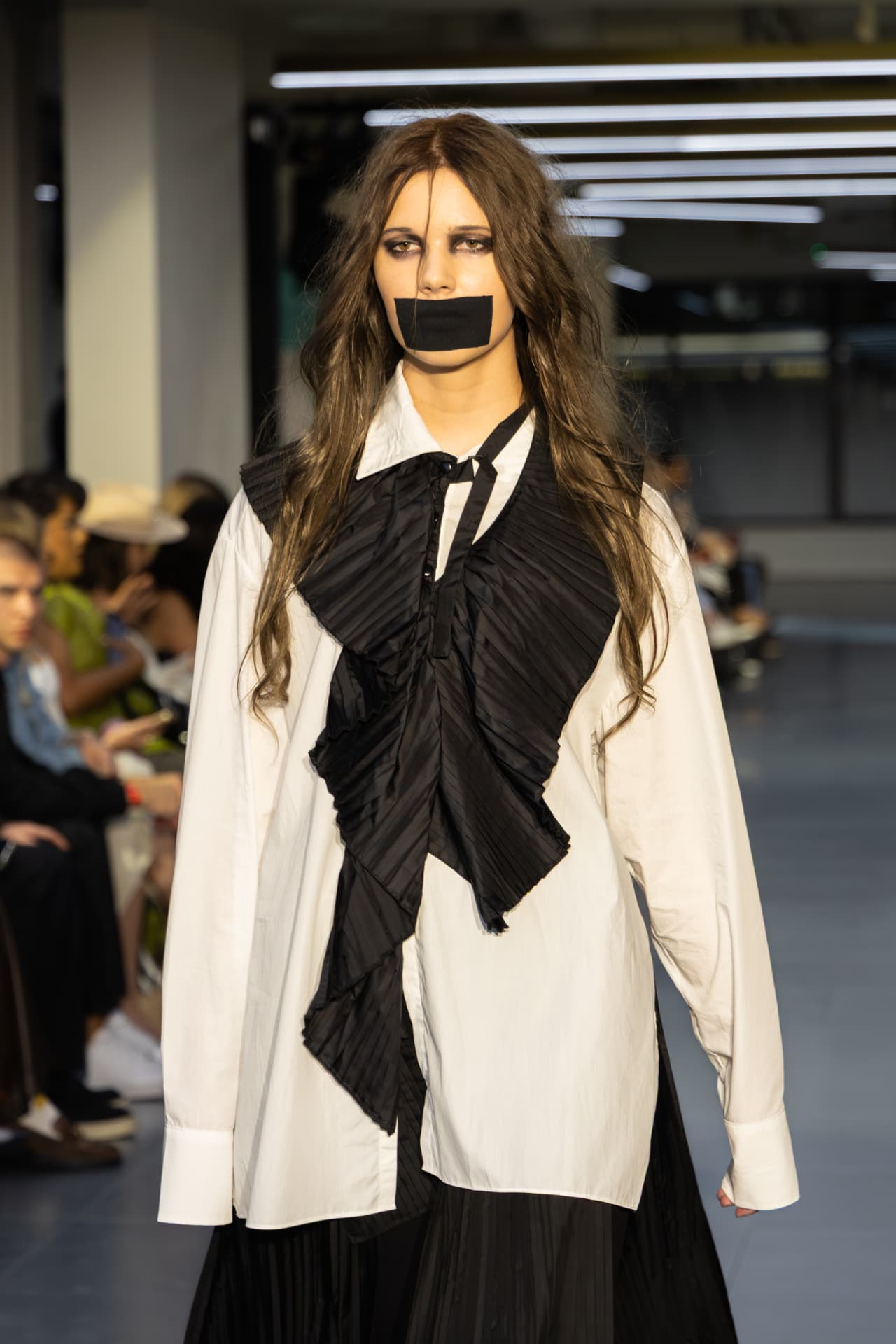 Model in a white shirt with black pleated ruffle detail