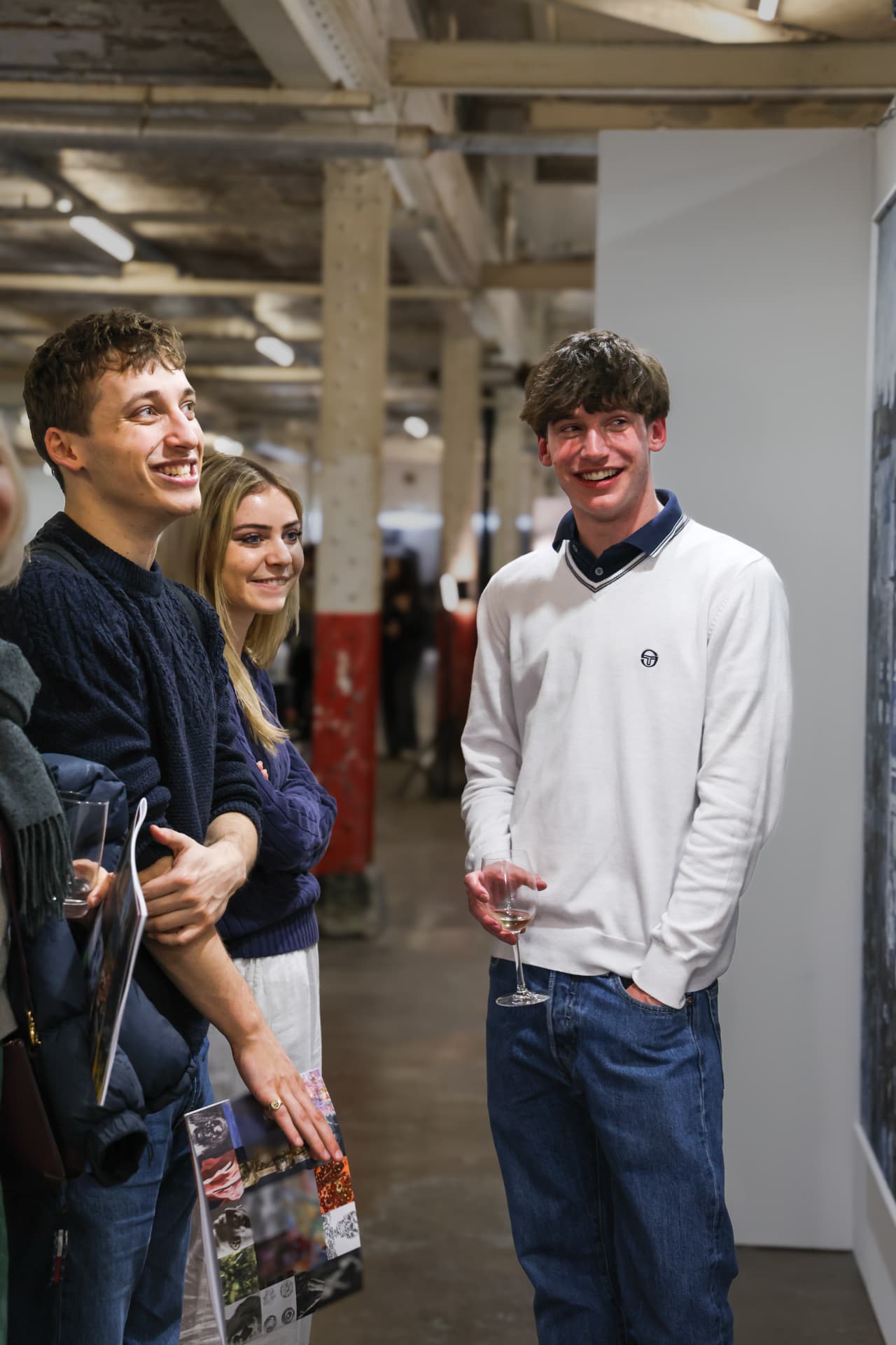 Group of guests laughing while viewing artwork