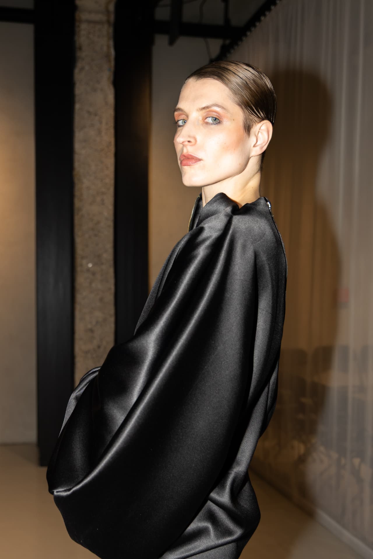Model in black satin draped jacket