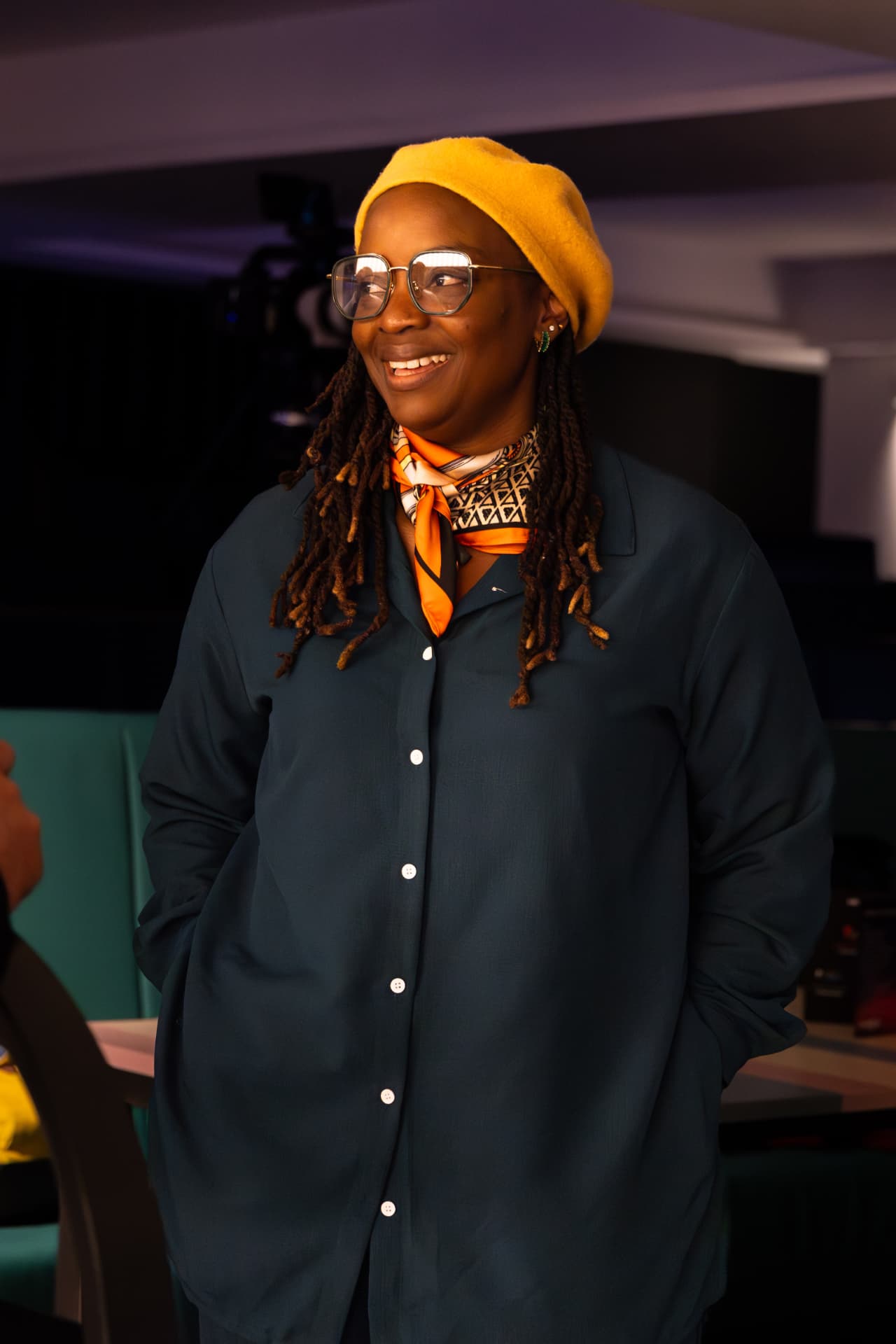 Guest in a yellow beret smiling at the event