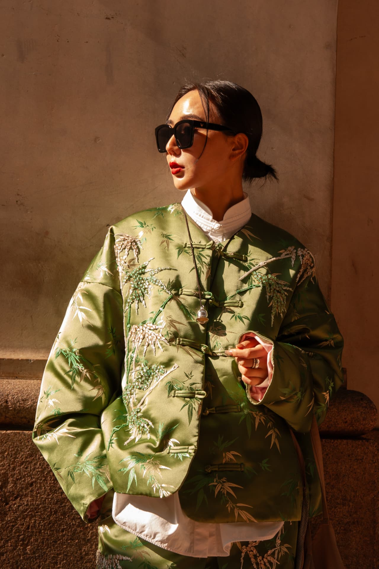Guest in an embroidered green silk jacket in warm sunlight