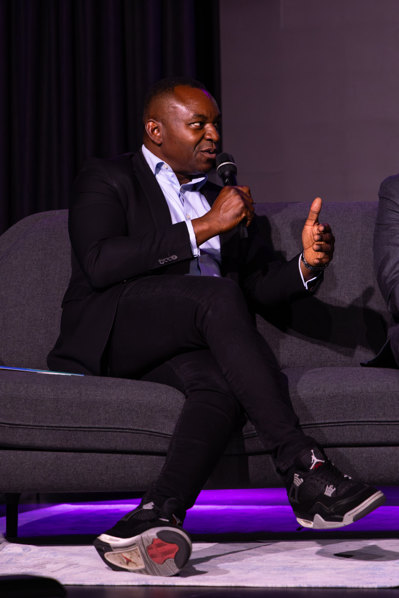 Panellist speaking into a microphone on stage