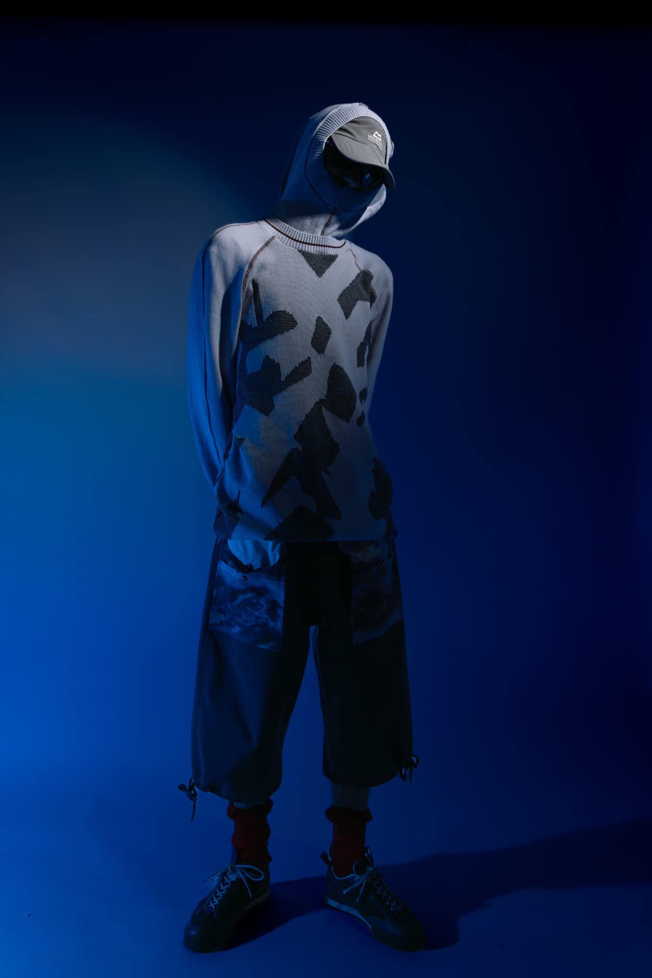 Full-length studio shot of a hooded knit and cropped trousers