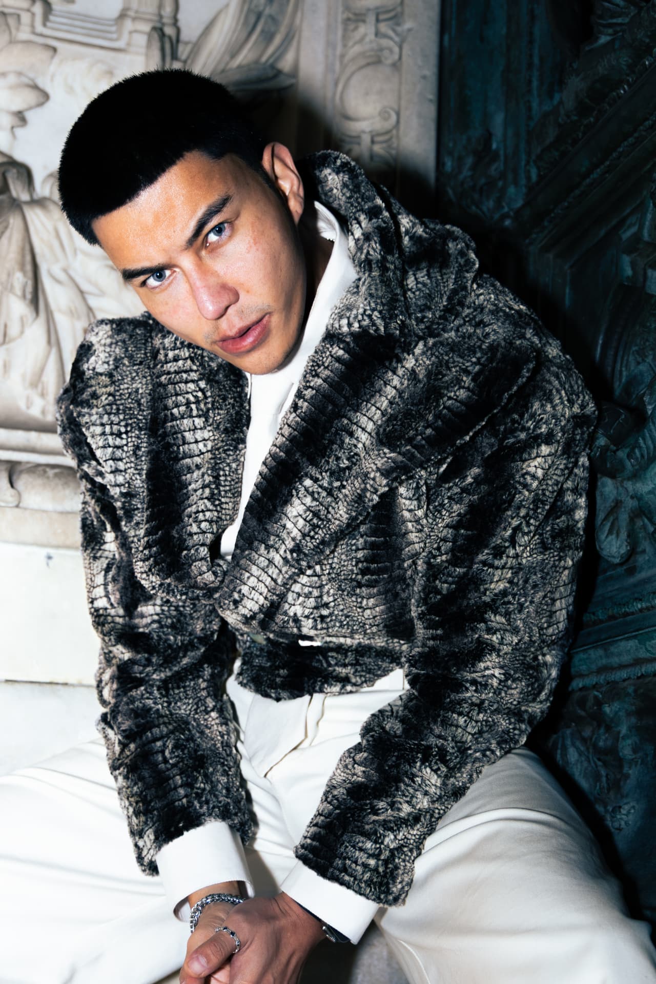 Model in a textured grey fur jacket and cream trousers