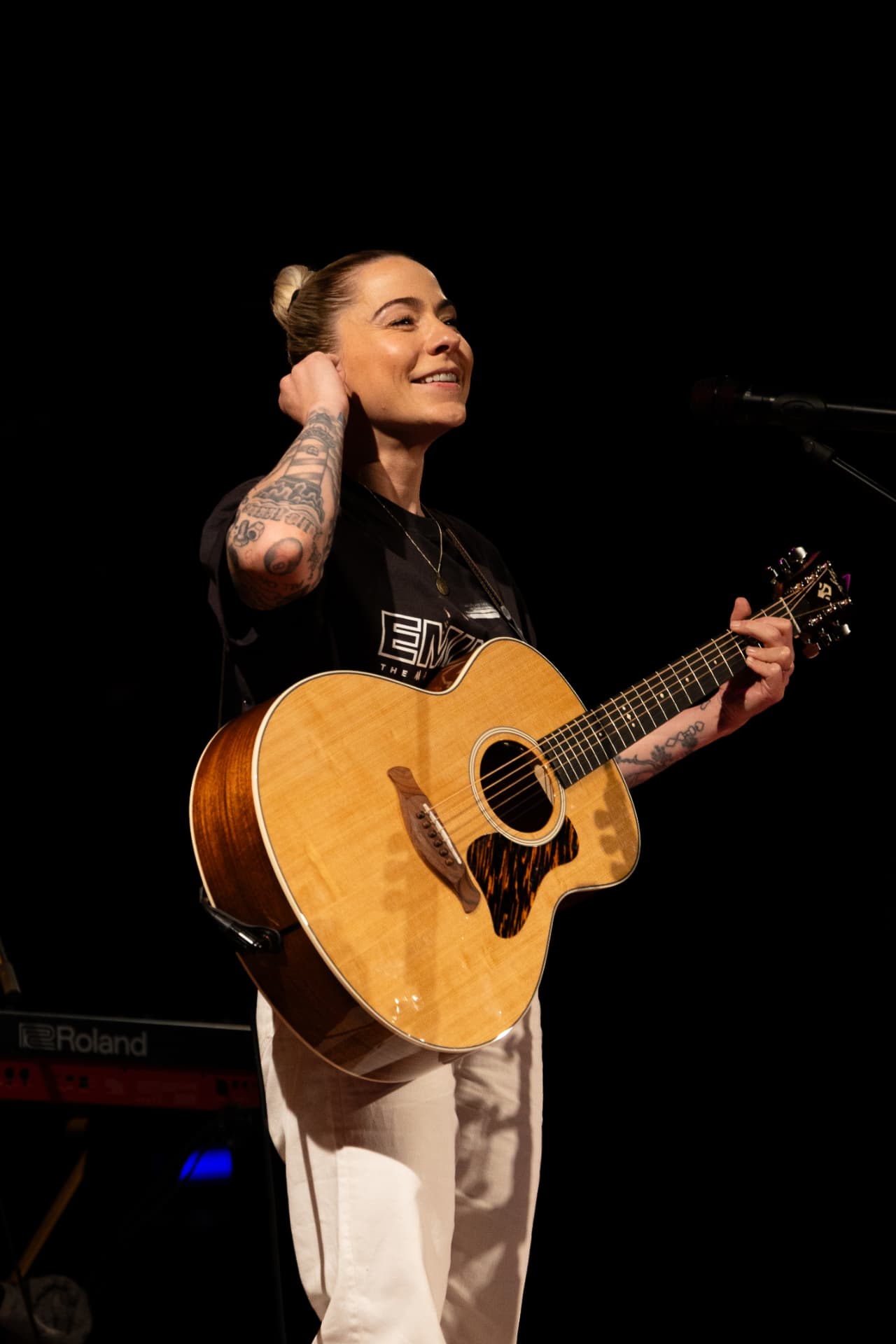 Smiling with hand behind head holding acoustic guitar