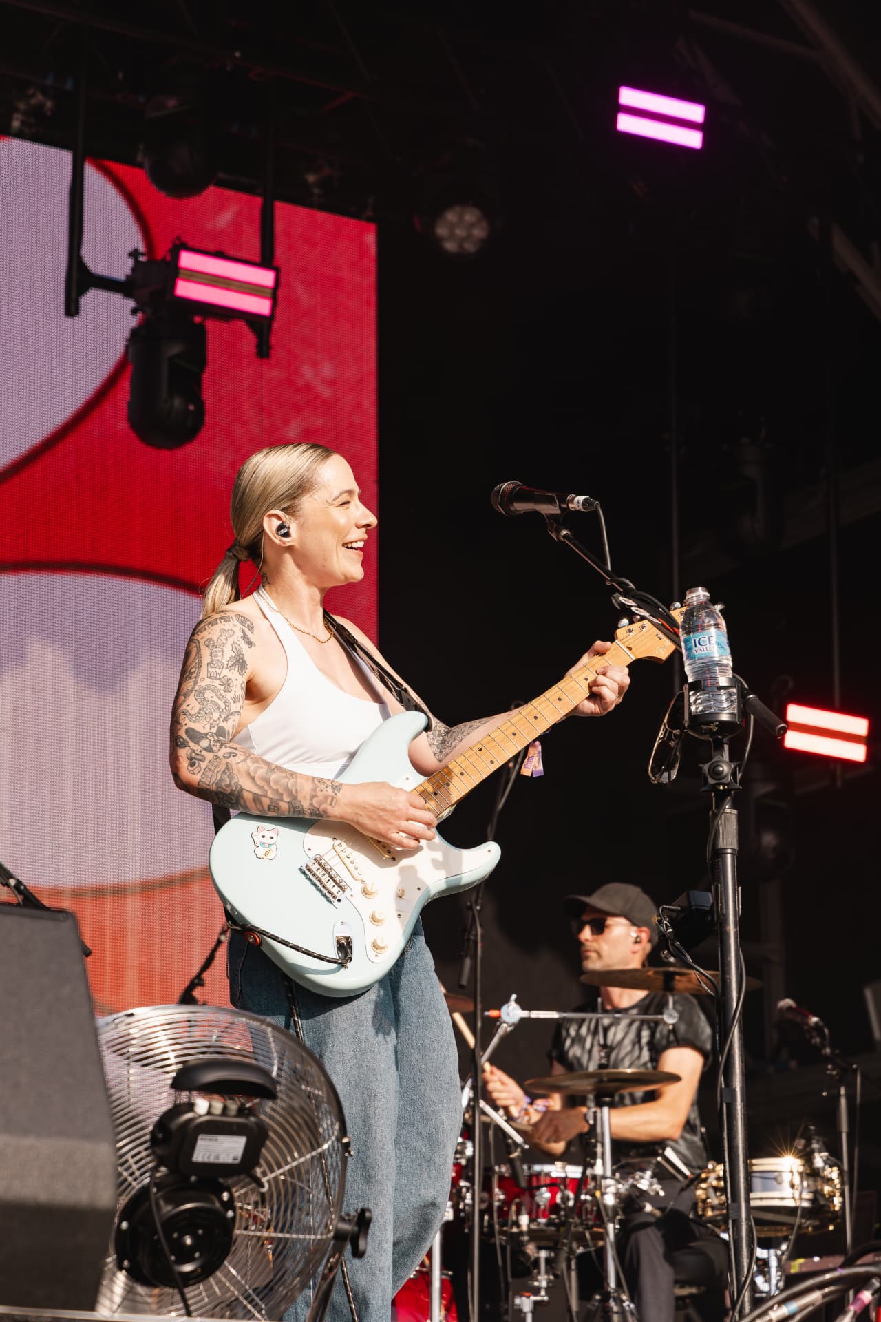 Singer playing a pale blue guitar in the sun