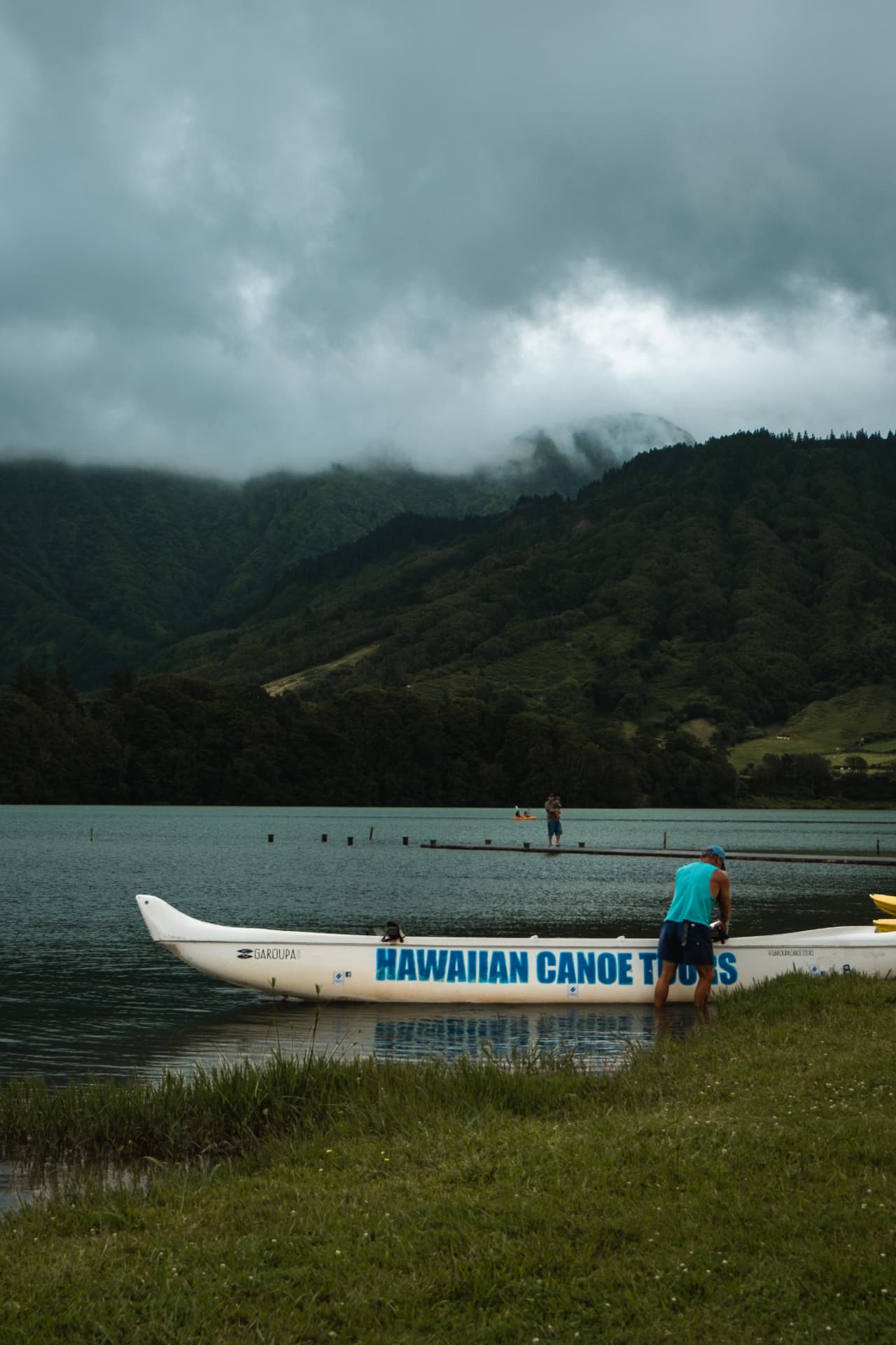 Hawaiian canoe pulled ashore on a lake under grey skies