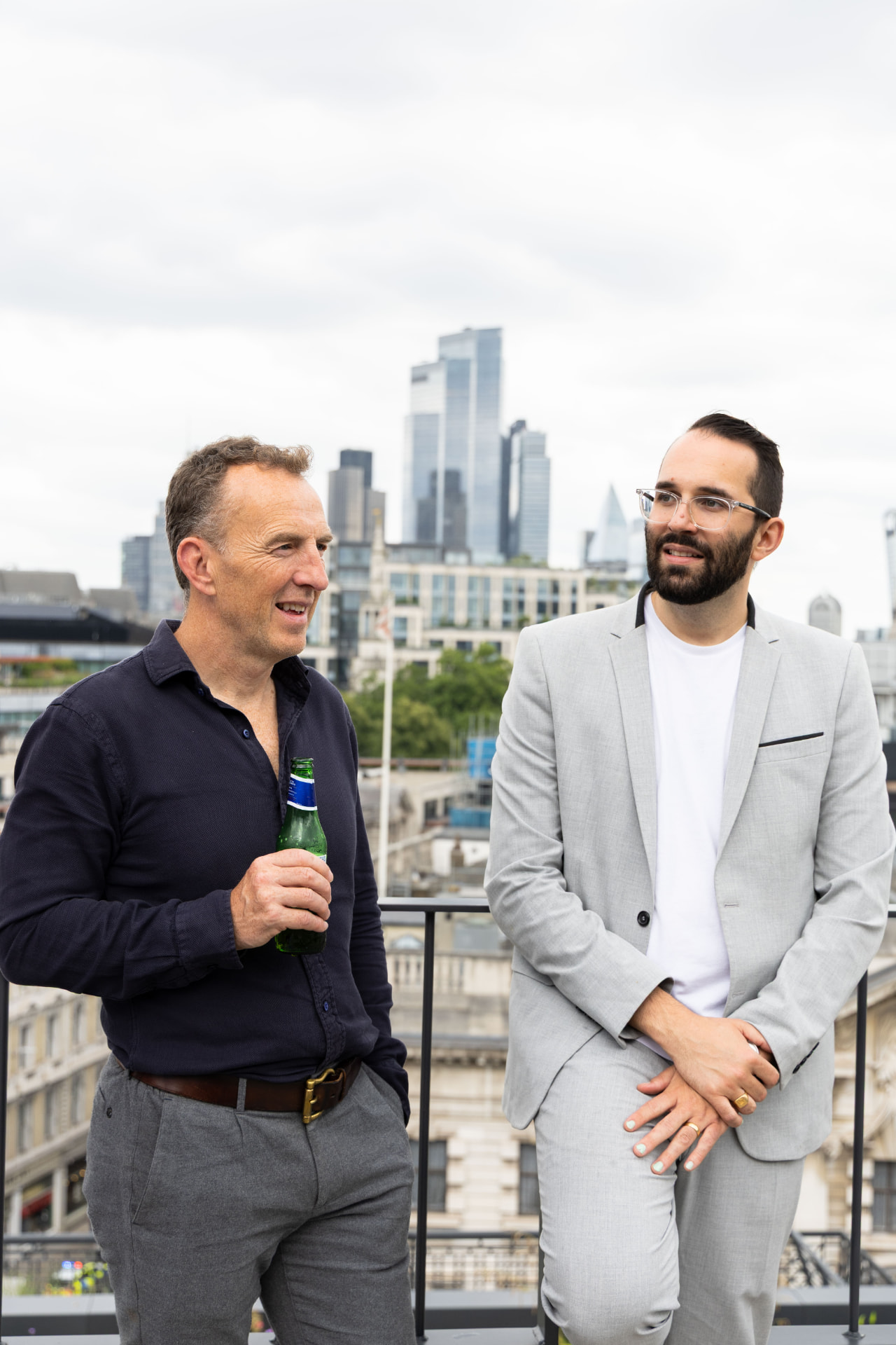Two guests chatting on the terrace with the City skyline behind