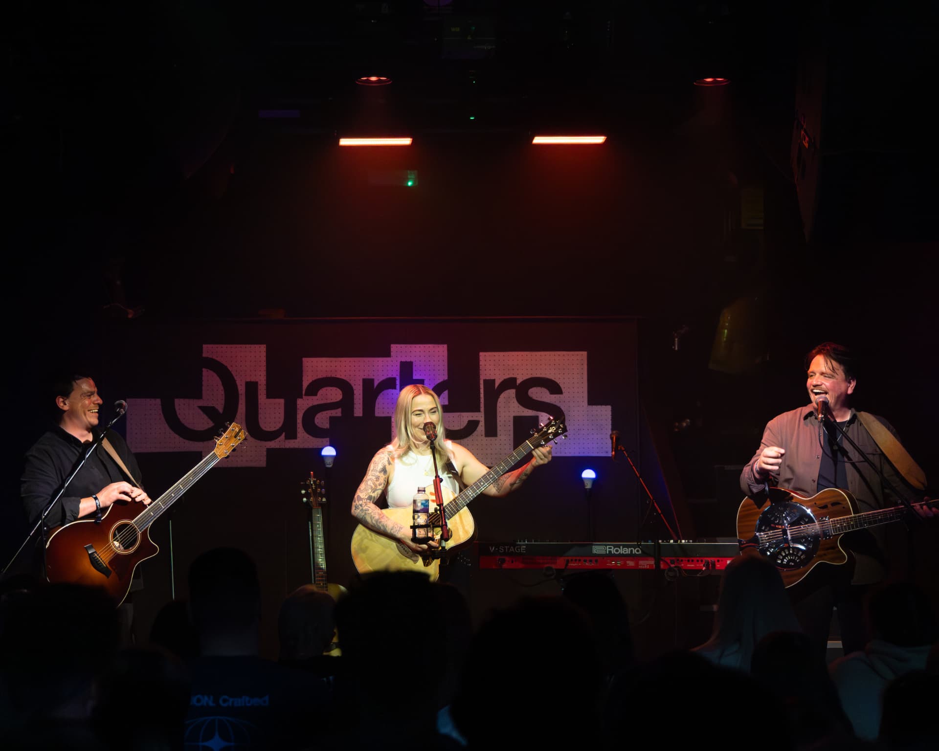 Wide shot of the three-piece band on stage at Quarters
