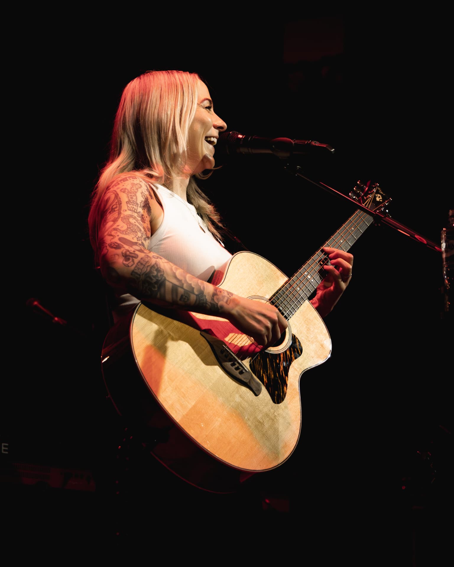 Side profile singing into the mic in red light