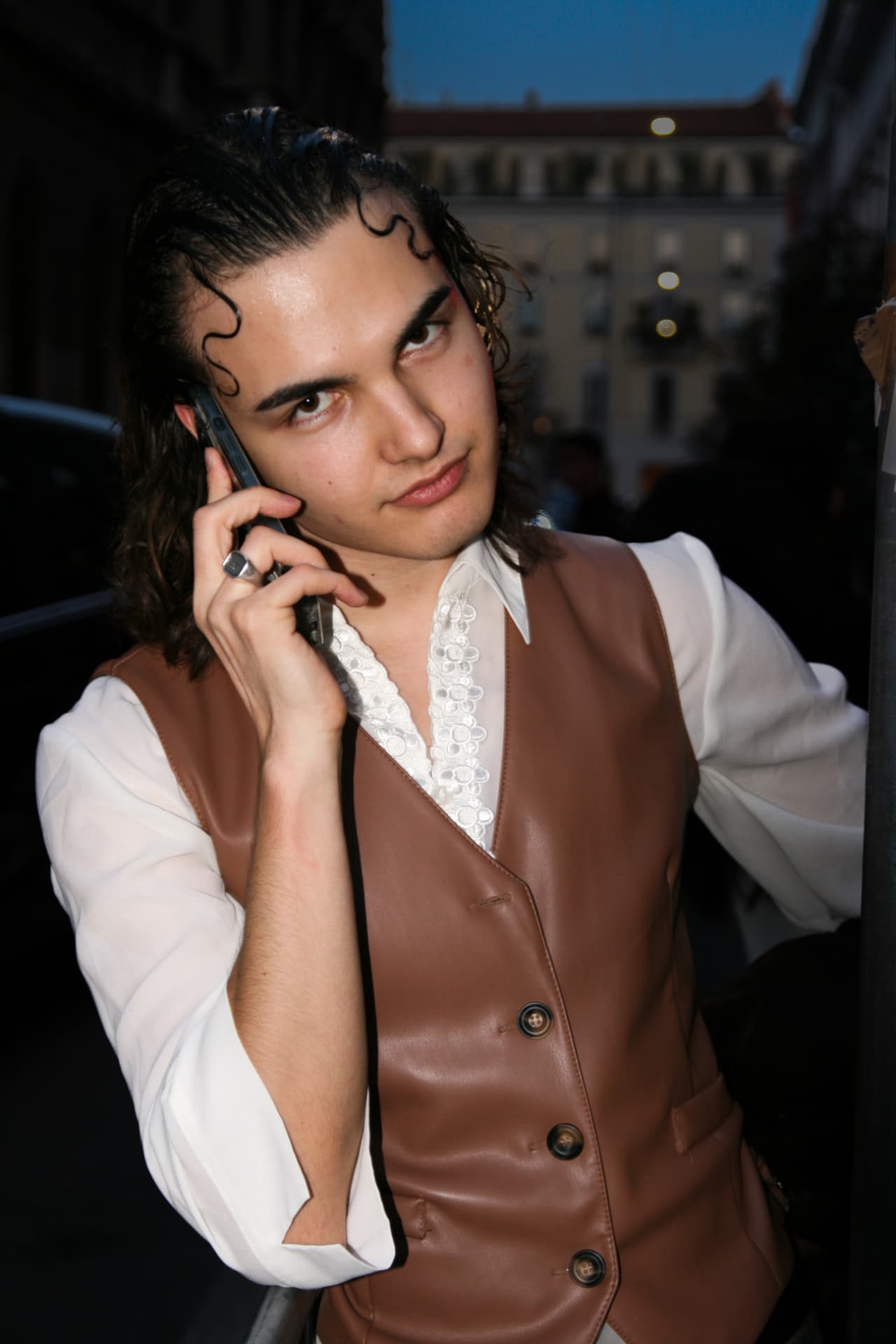 Guest in a brown leather waistcoat and white shirt on the phone