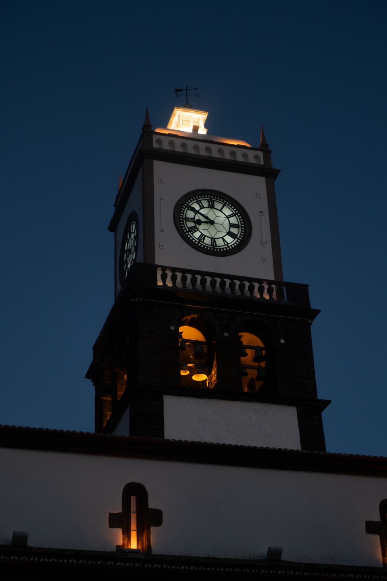 Illuminated church clock tower at dusk