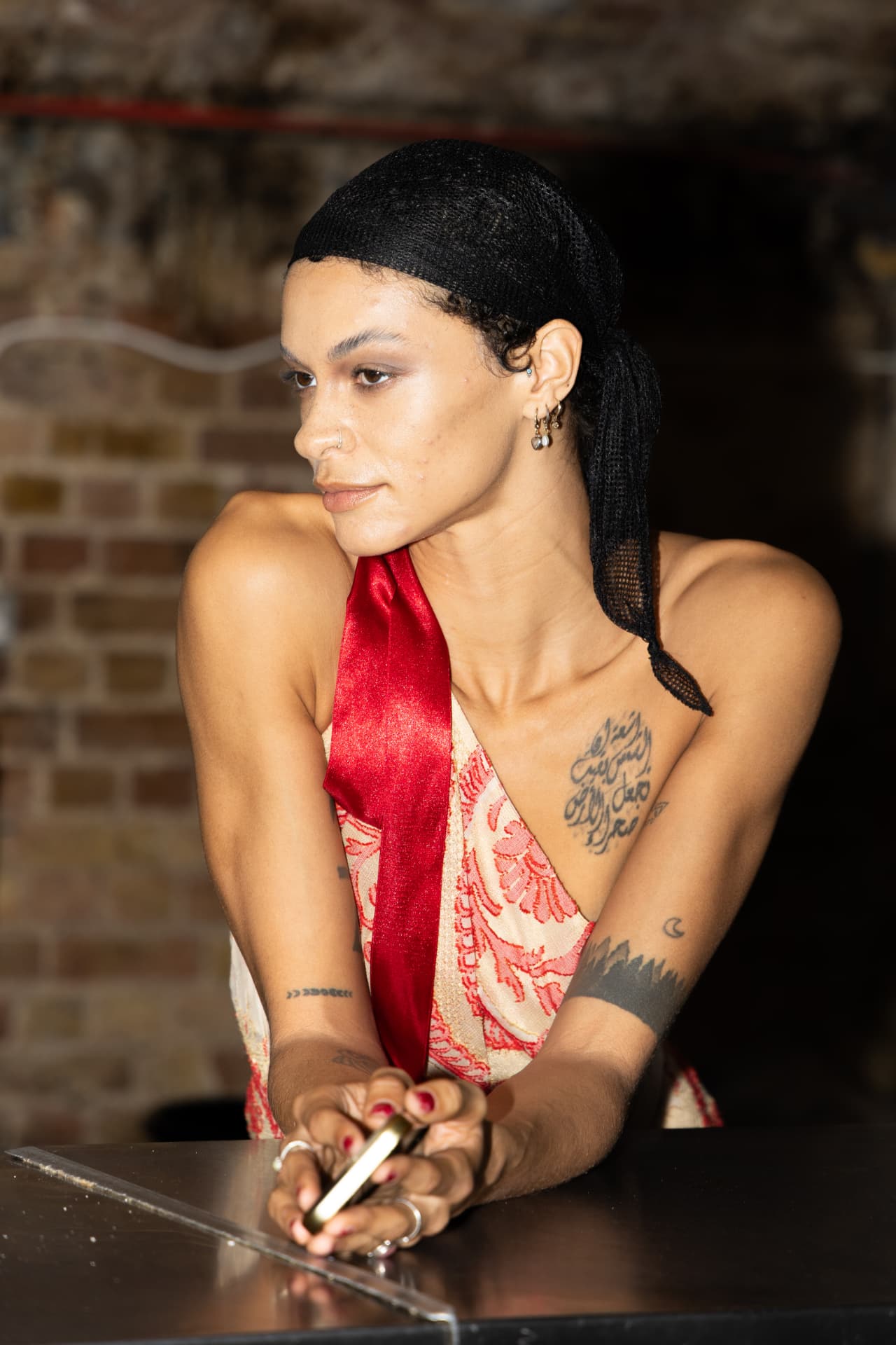 Model in red and cream slip dress with headscarf